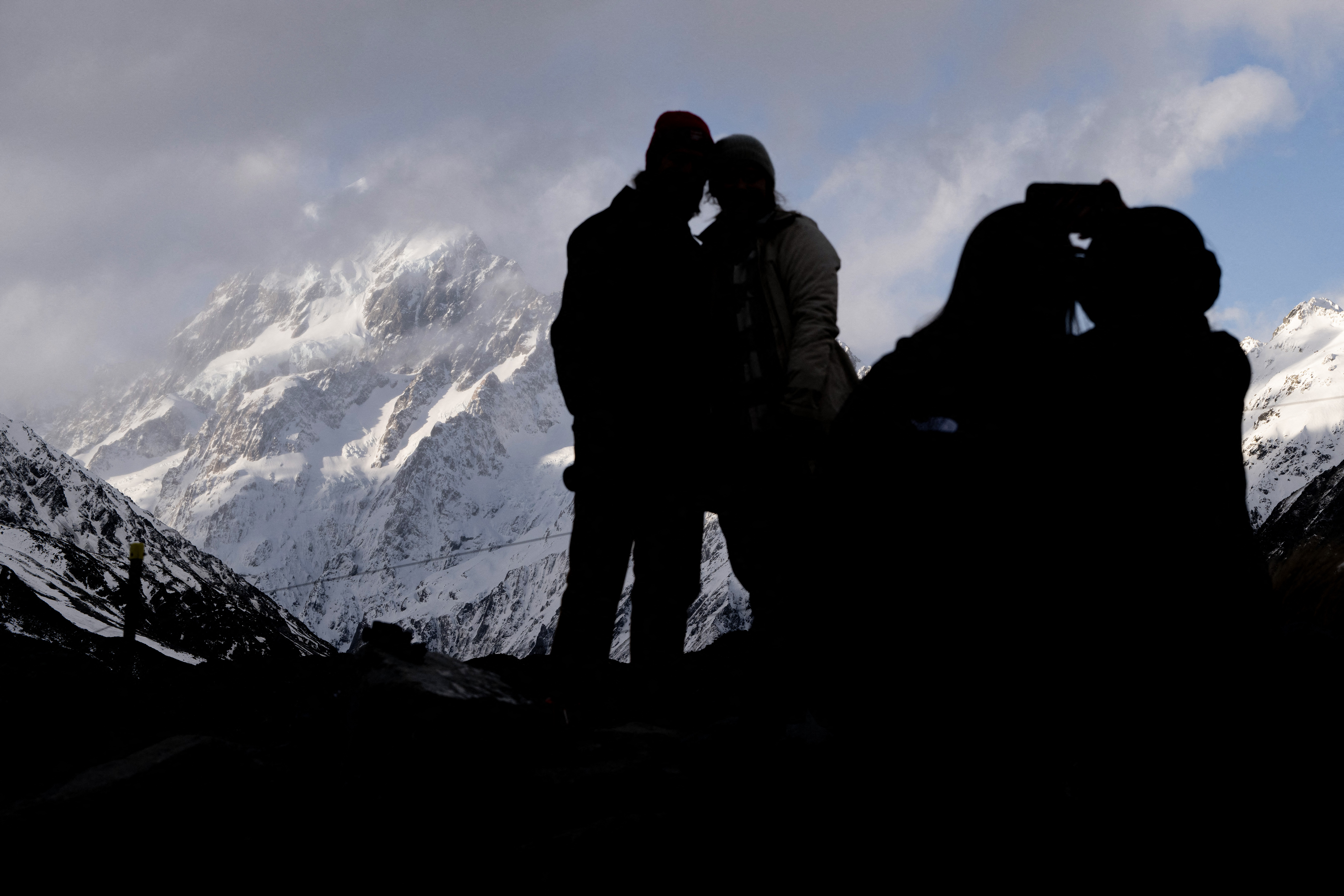 Visitors take pictures in front of Mount Cook, also known as Aoraki in Maori, one of New Zealand's most iconic landmarks that sits in the Southern Alps mountain range on New Zealand's South Island