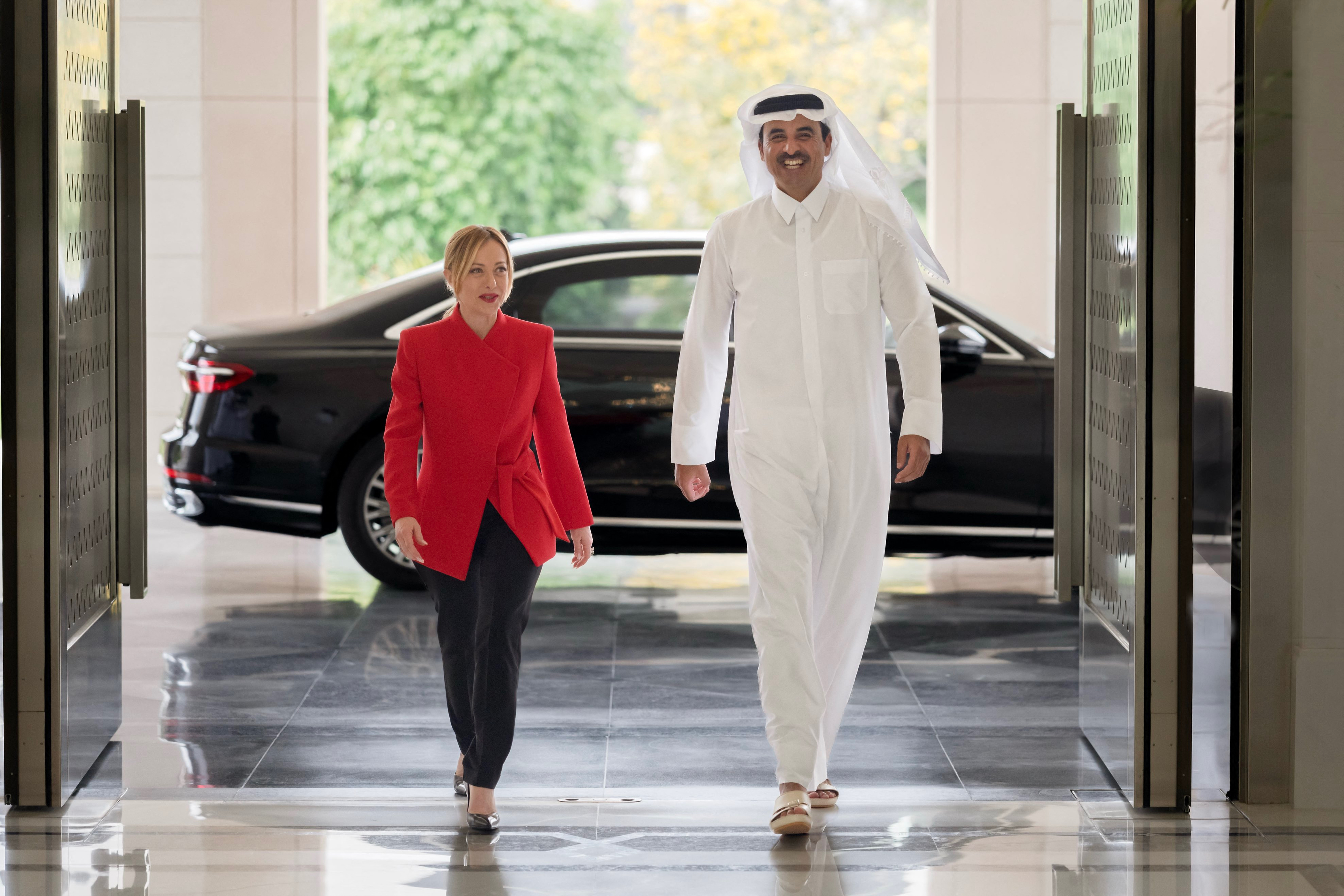 This handout photograph taken and released by Qatar's Amiri Diwan shows Qatar's Emir Sheikh Tamim bin Hamad Al-Thani receiving Italy's Prime Minister Giorgia Meloni during their meeting at Lusail Palace on April 4, 2026.