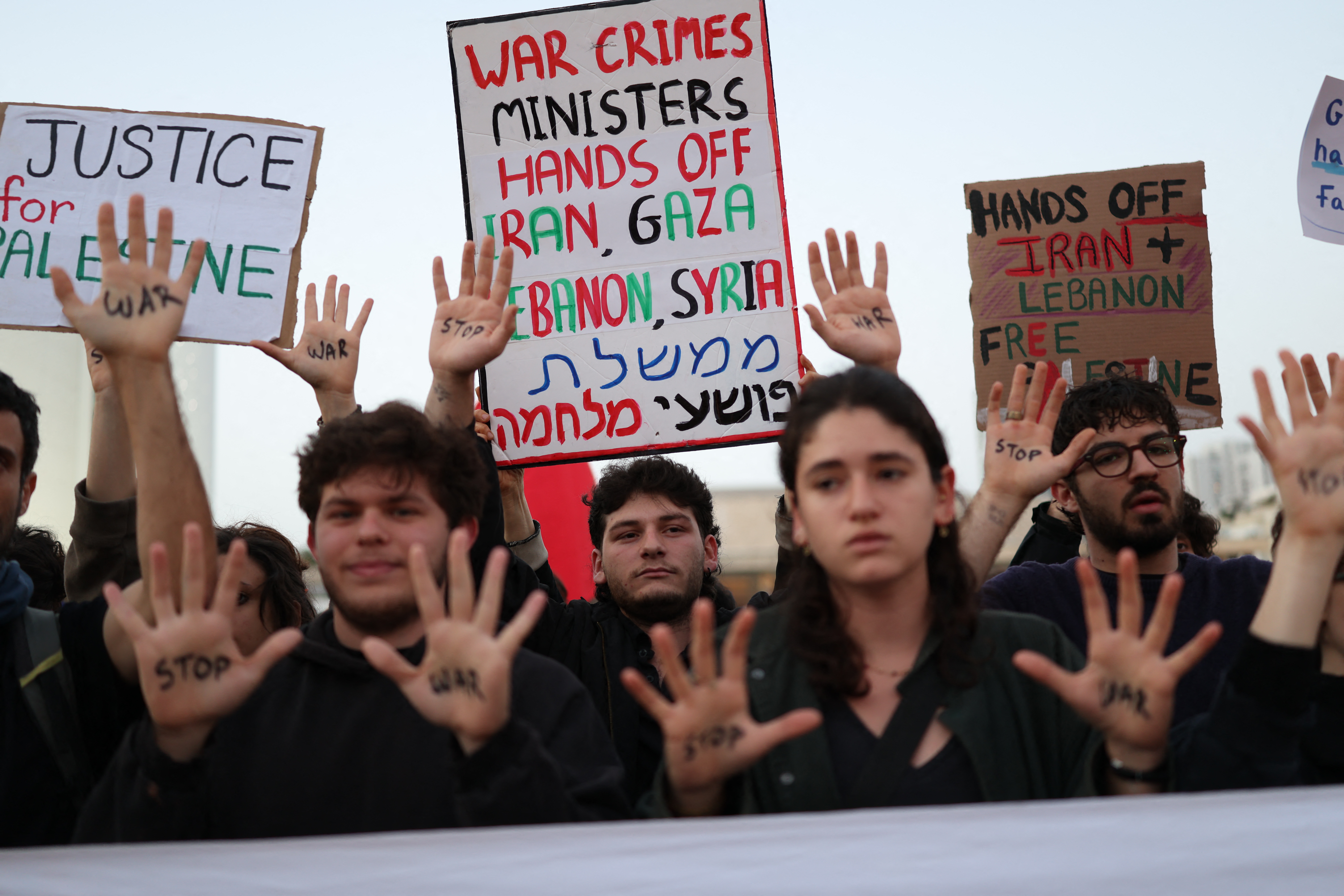 Israeli left-wing activists hold placards while taking part in a protest at HaBima Square in Tel Aviv on April 4, 2026, against the ongoing war with Iran