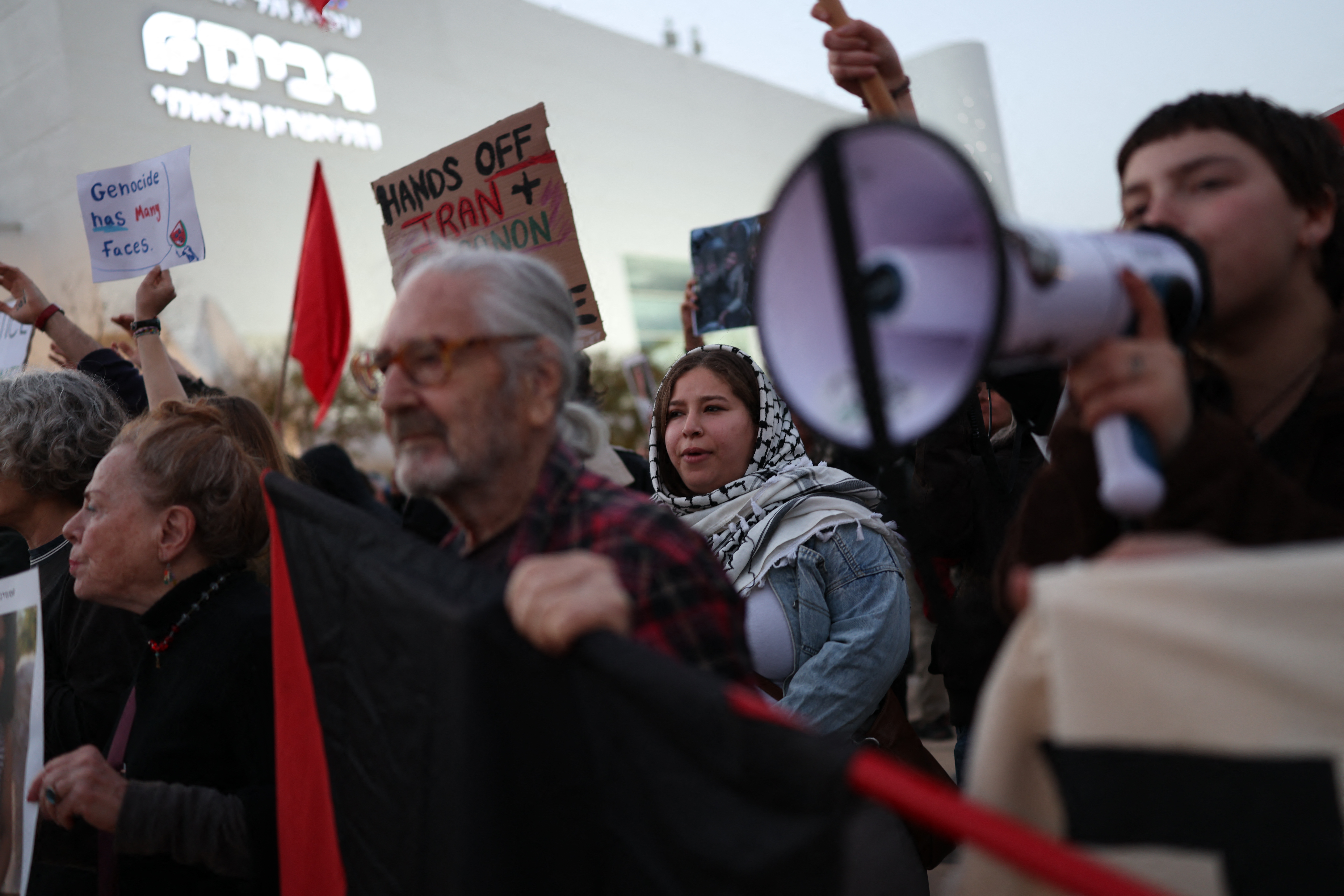 Israeli left-wing activists hold placards while taking part in a protest at HaBima Square in Tel Aviv on April 4, 2026, against the ongoing war with Iran.