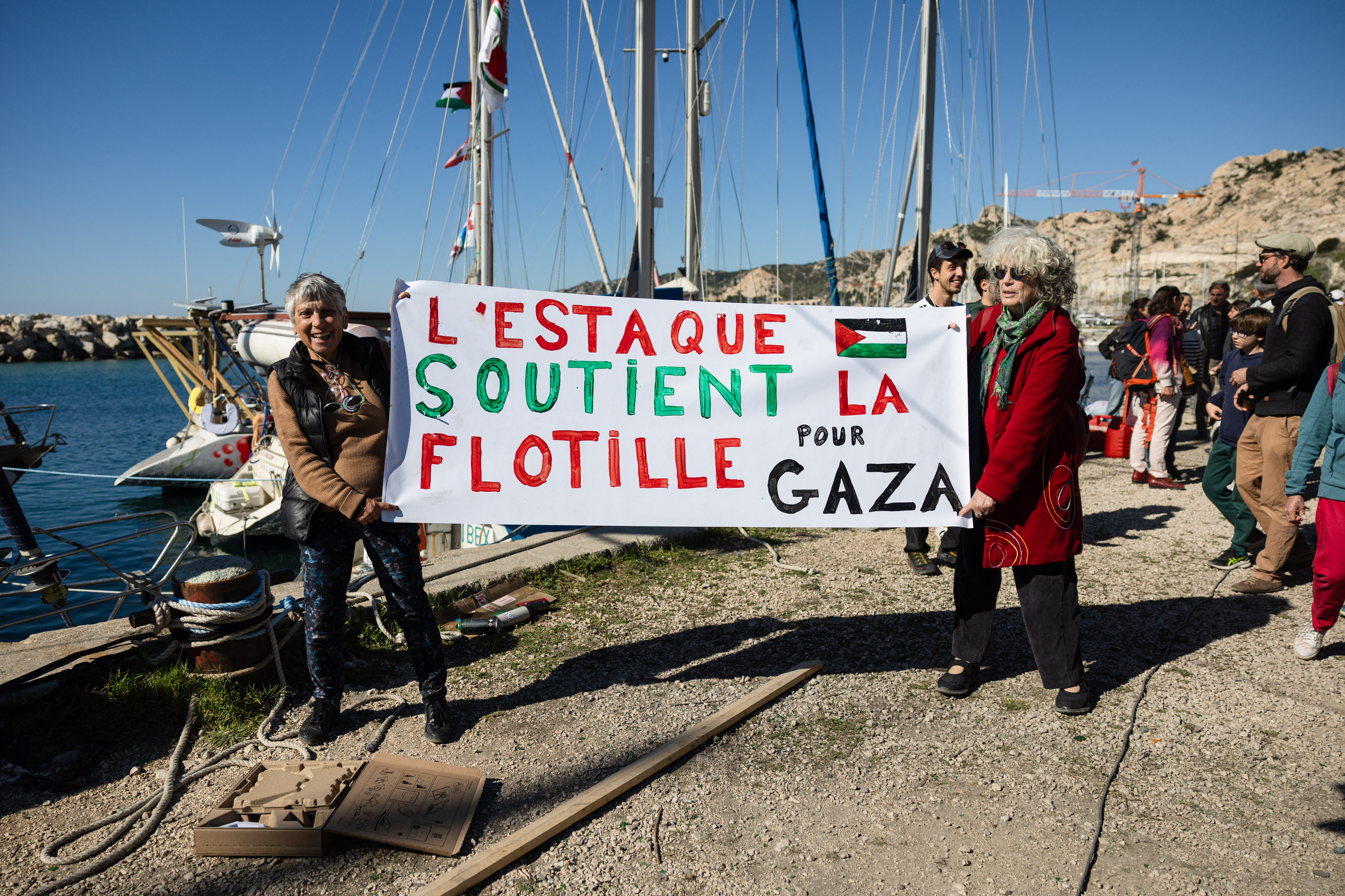 Activists hold a banner reading "L'Estaque supports the flotilla to Gaza" in l'Estaque, part of Marseille's harbour, southern France, on April 4, 2026
