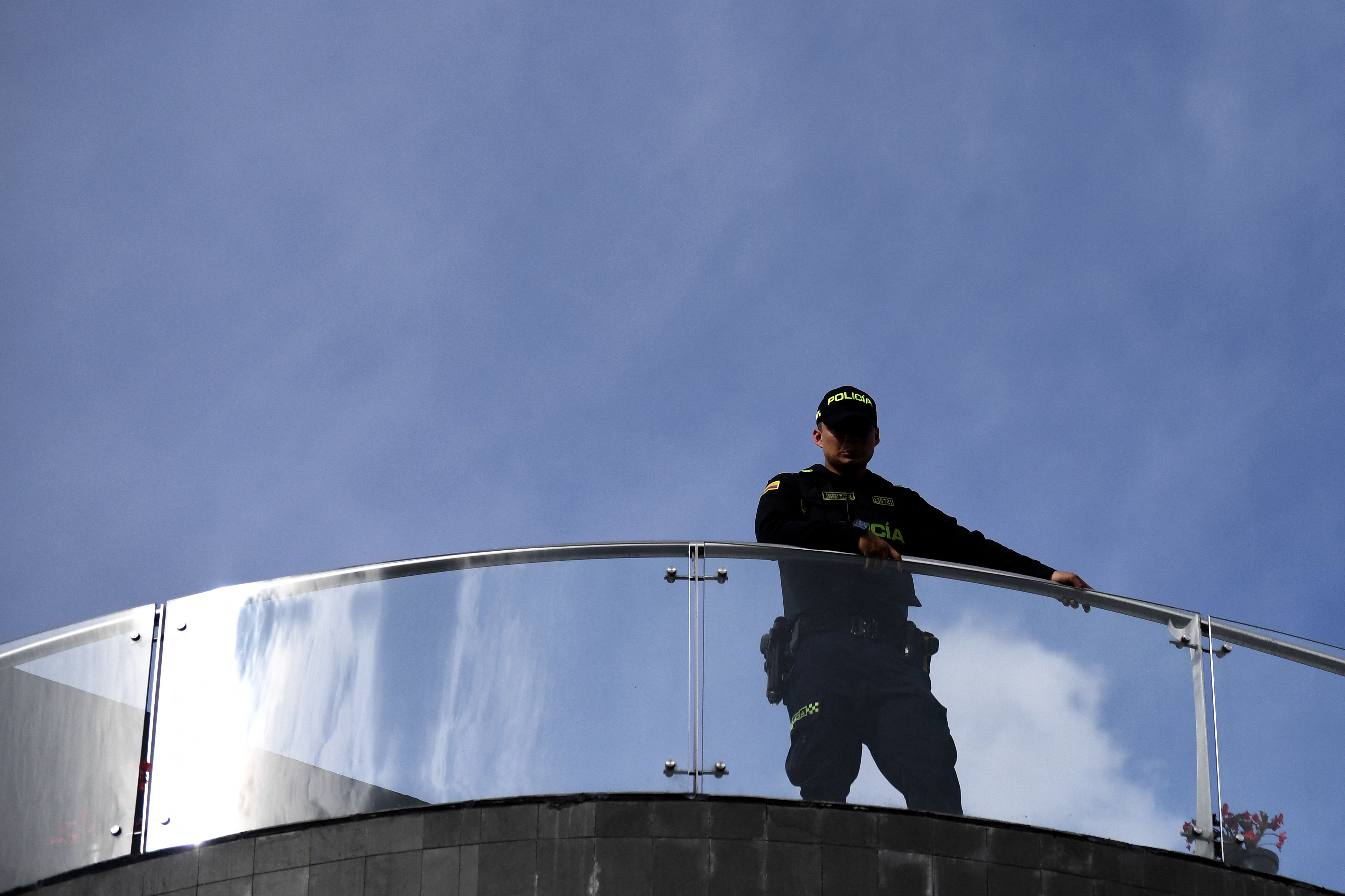 A Colombian police officer stands guard on a rooftop during a campaign rally of Colombia's right-wing presidential candidate Abelardo de la Espriella, from the Defensores de la Patria movement, in Envigado, Antioquia department, Colombia on May 13, 2026.
