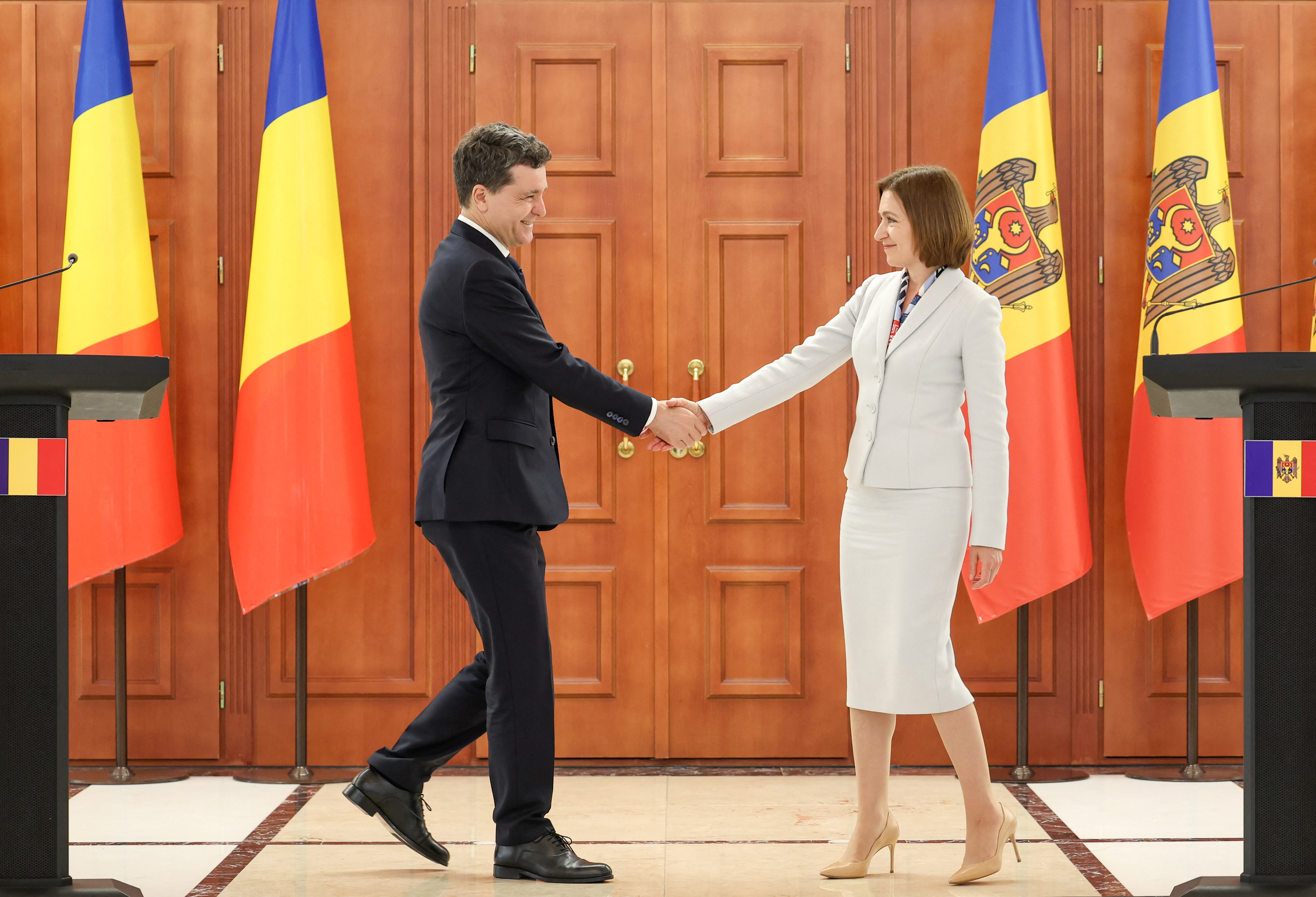 Moldova's President Maia Sandu (R) and Romania's President Nicusor Dan (L) shake hands during a joint press conference following a meeting at the presidency headquarters in Chisinau on June 10, 2025. (Photo by Elena COVALENCO / AFP)