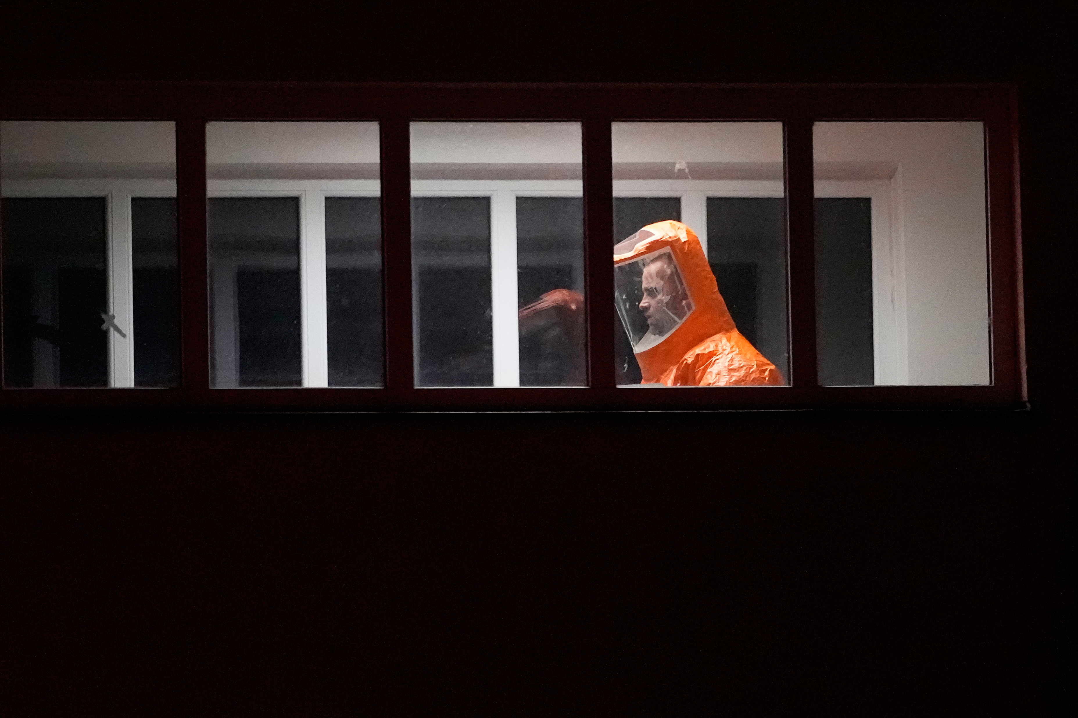 A medical staff member, in protective gear, walks to admit a U.S. doctor who was in contact with people infected with Ebola into a hospital in Prague, Czech Republic, Thursday, May 21, 2026. (AP Photo/Petr David Josek)