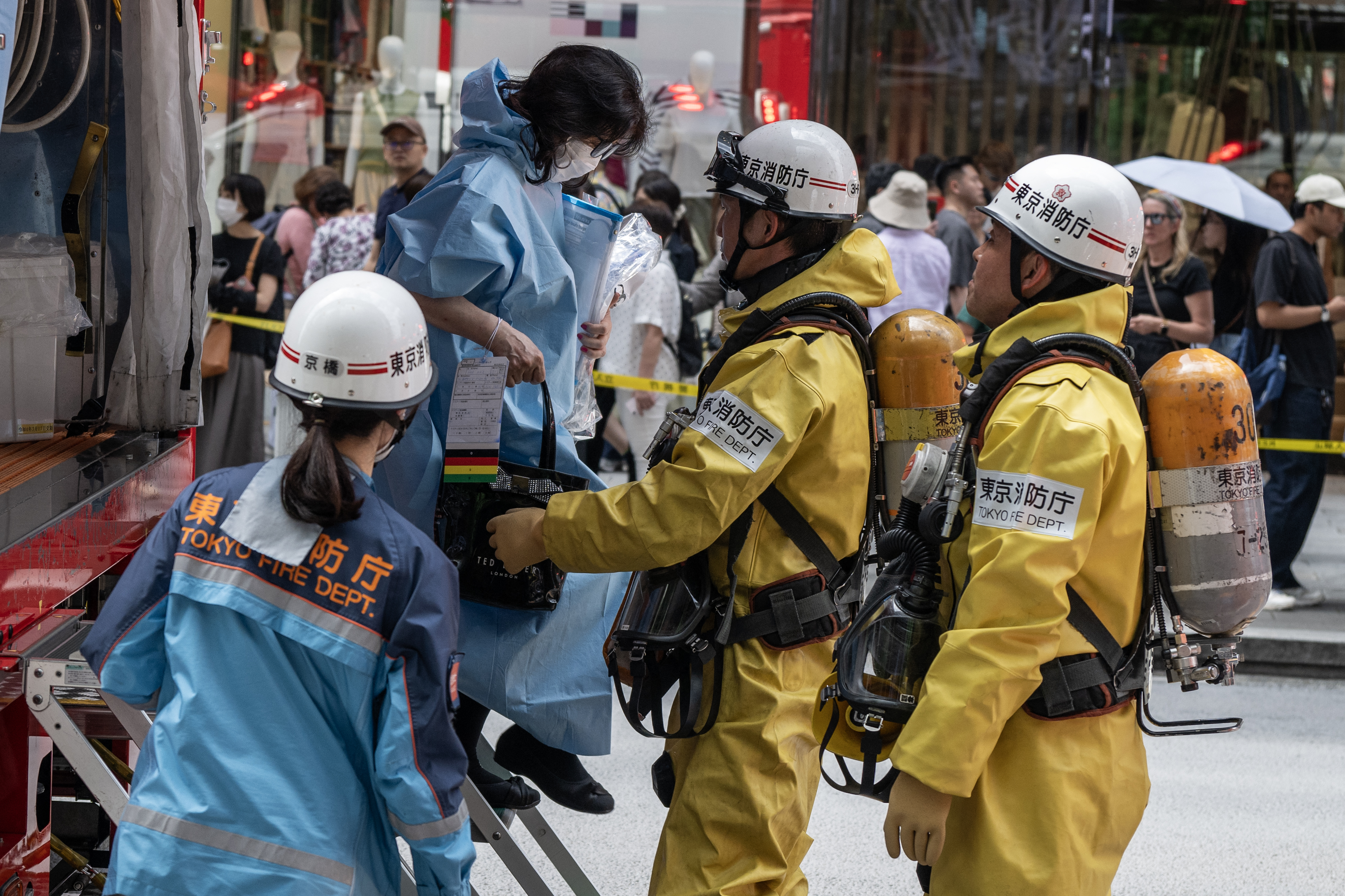 Emergency personnel help a woman that was inside the Ginza 6 Shopping Center out of an emergency vehicle in Tokyo on May 25, 2026