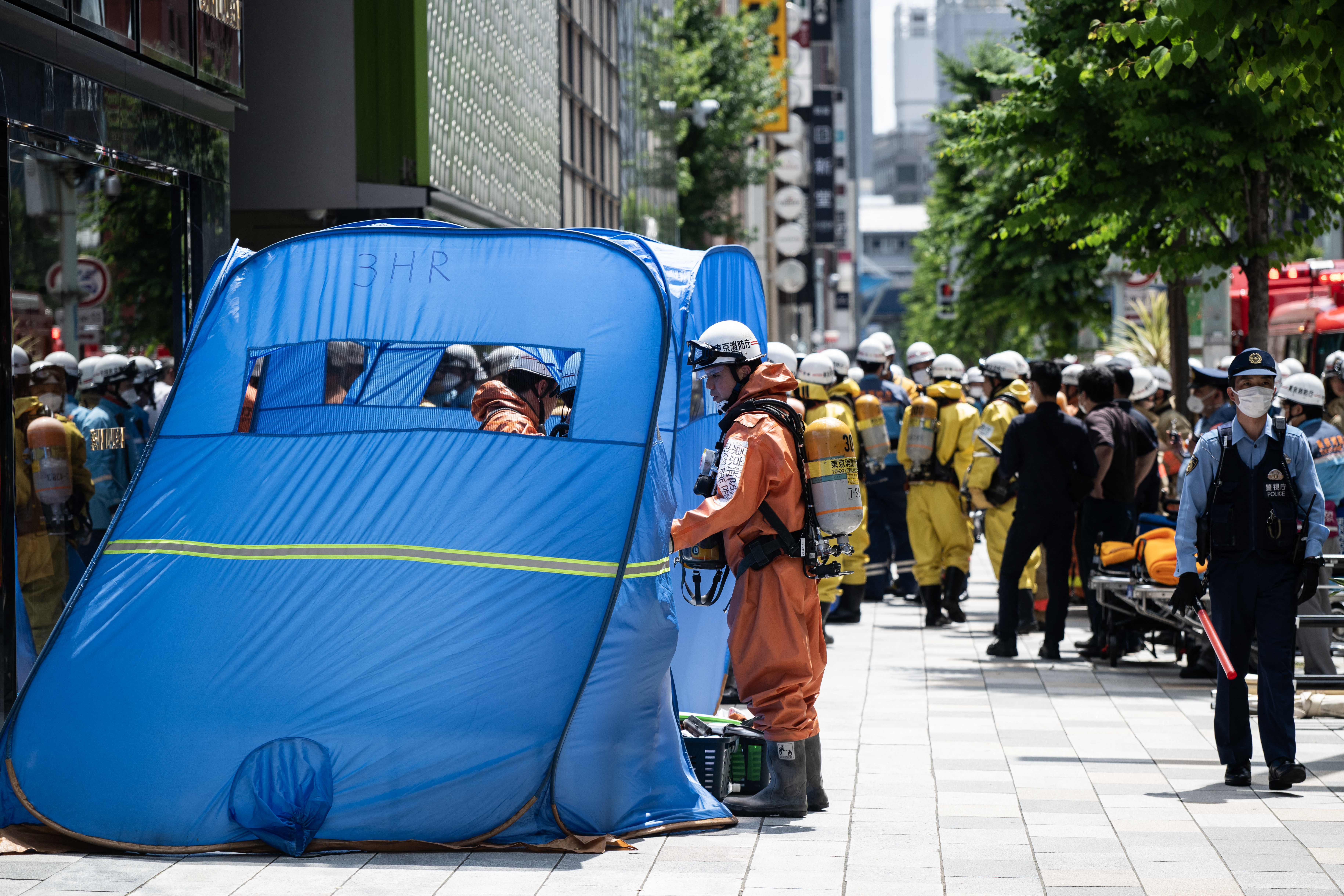 Emergency personnel are seen in front of the Ginza 6 Shopping Center in Tokyo on May 25, 2026, after an individual allegedly sprayed a substance in the area.