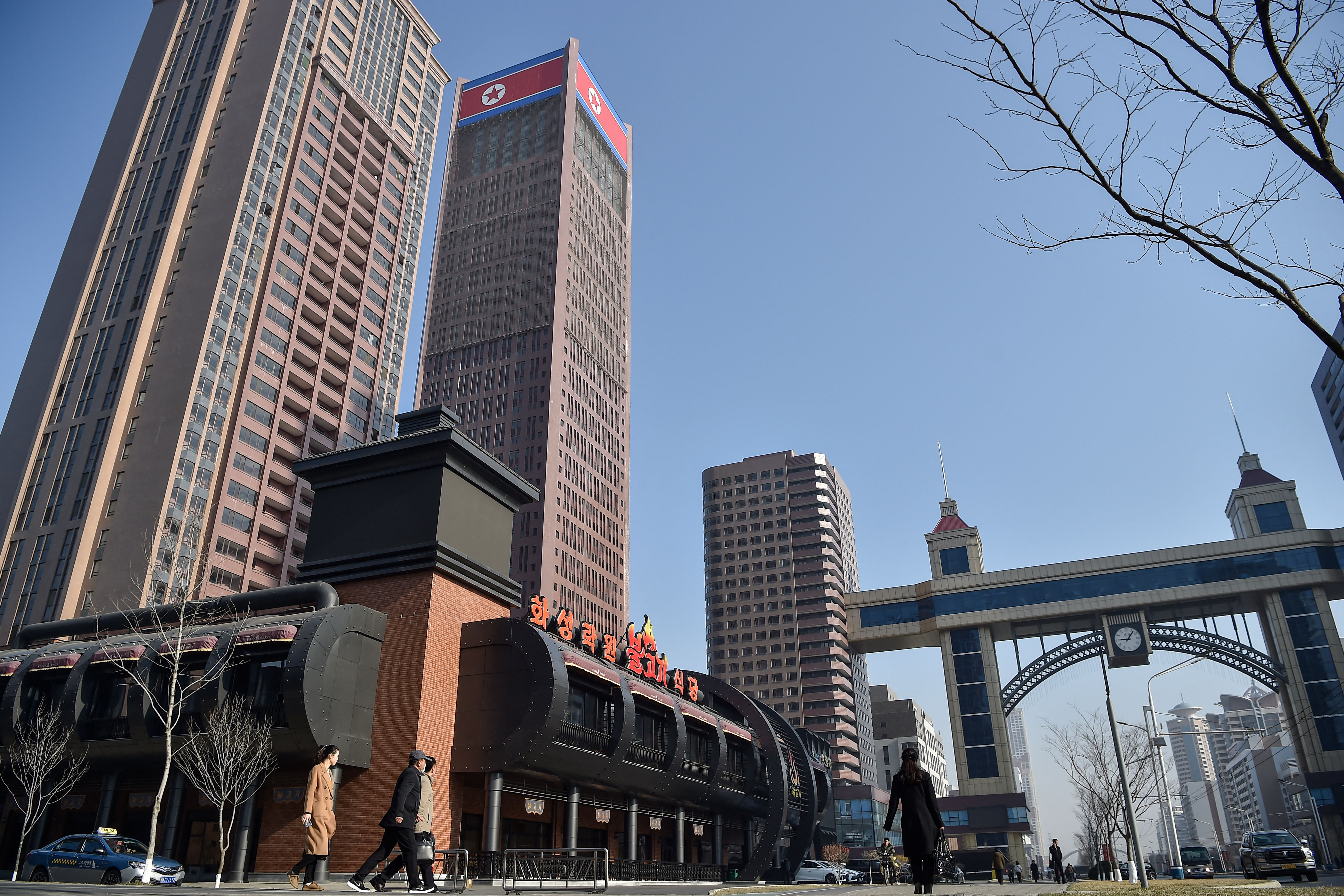 This general view shows people walking in a street of the third stage of the Hwasong area in Pyongyang on March 23, 2026.