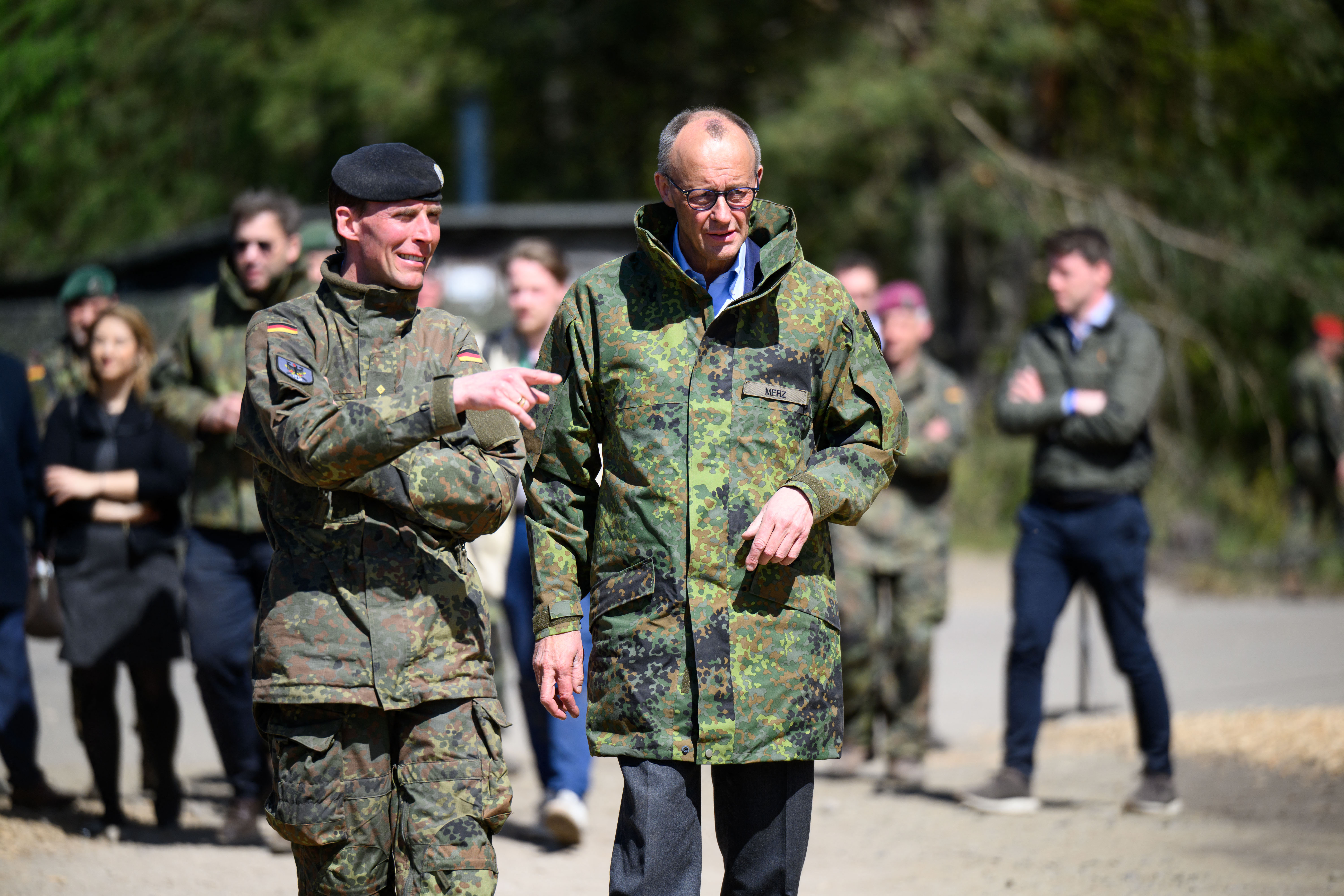 German Chancellor Friedrich Merz (R) is accompanied by the Inspector of the Army Christian Freuding. (Photo by DANIEL REINHARDT / AFP)