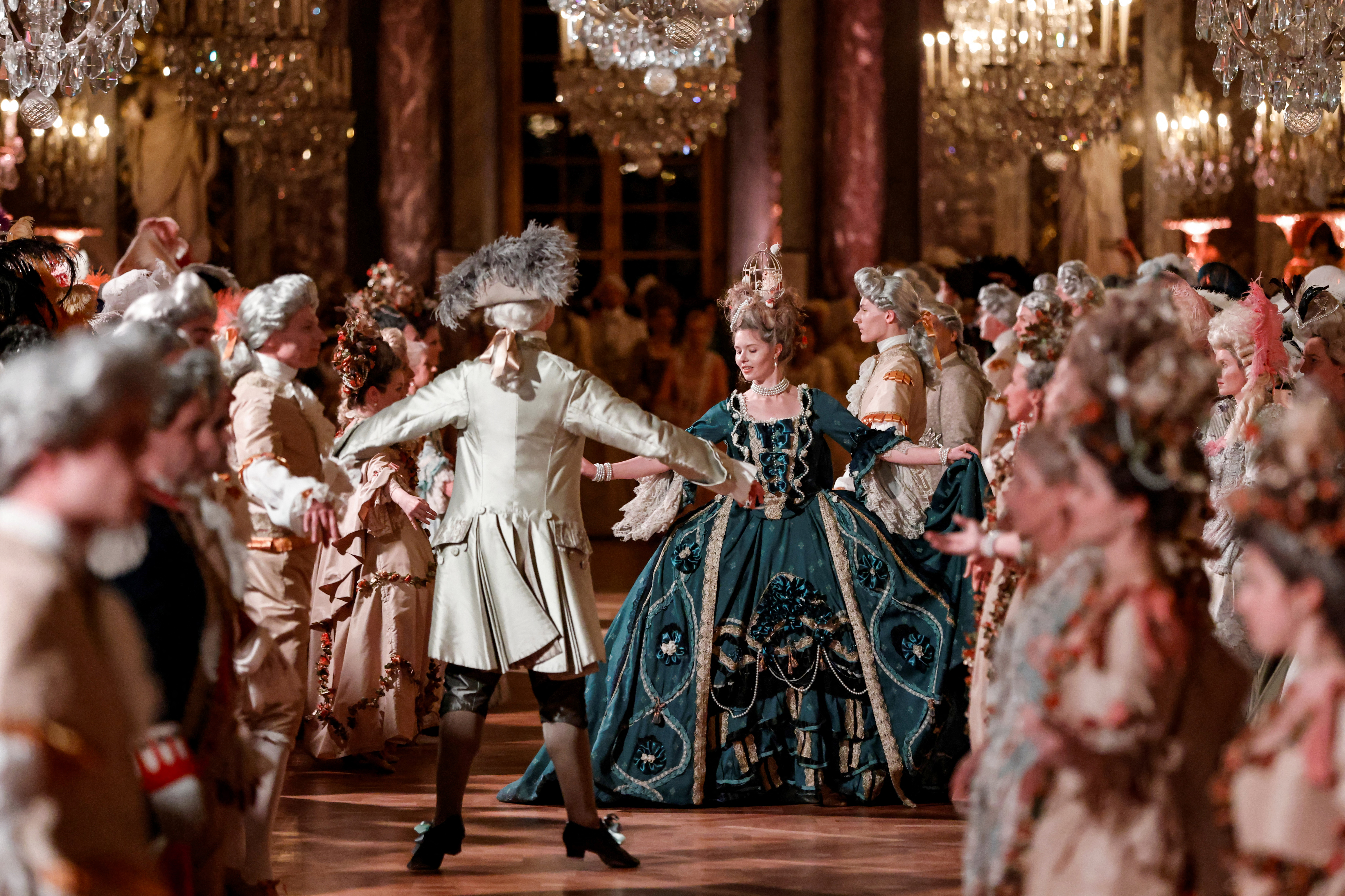 Guests wearing baroque style costumes take part in a ball in the Hall of Mirrors. (Photo by Ludovic MARIN / AFP)