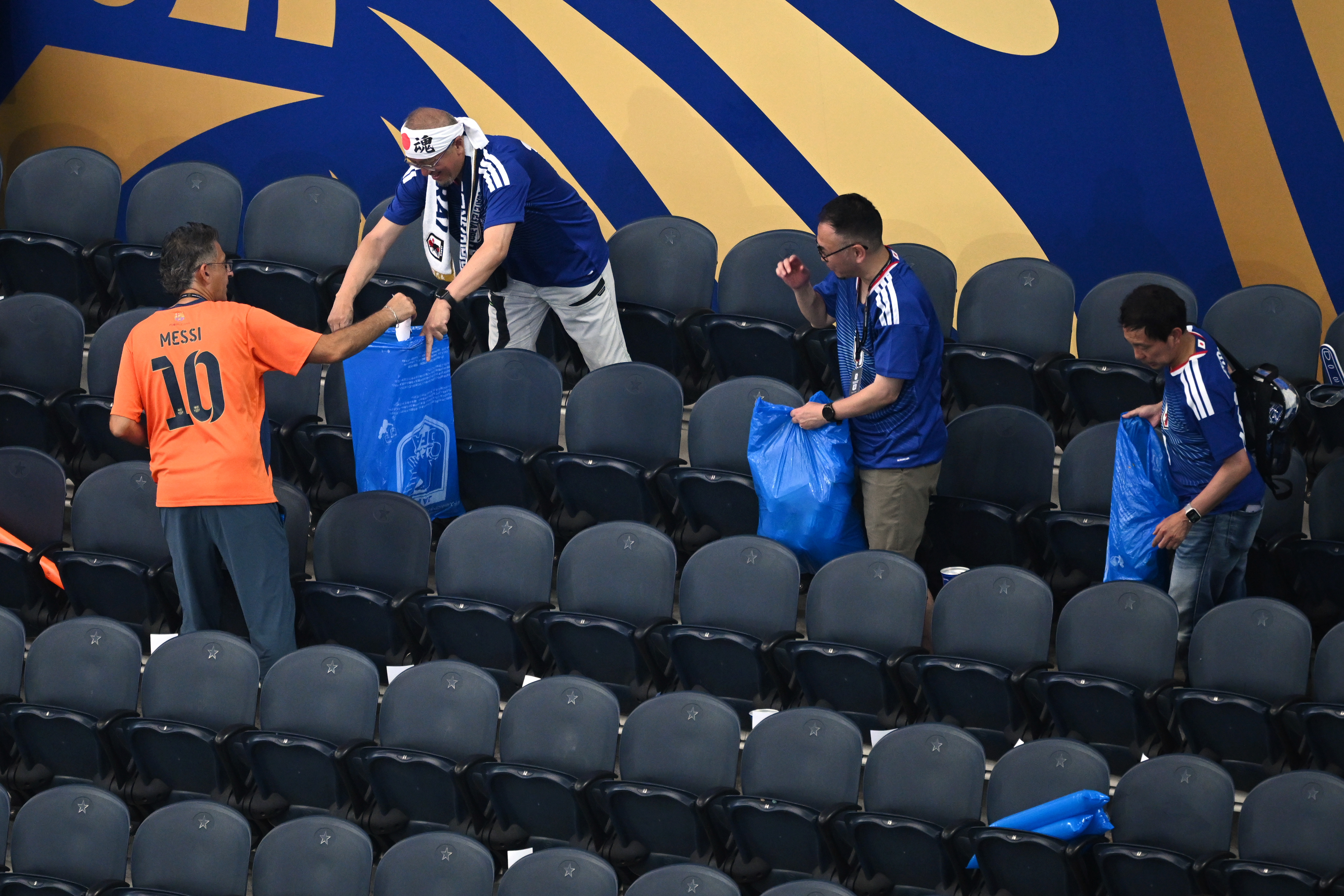 Japan fans clean up trash in the stadium following the World Cup Group F soccer match between the Netherlands and Japan in Arlington, Texas, near Dallas, Sunday, June 14, 2026.