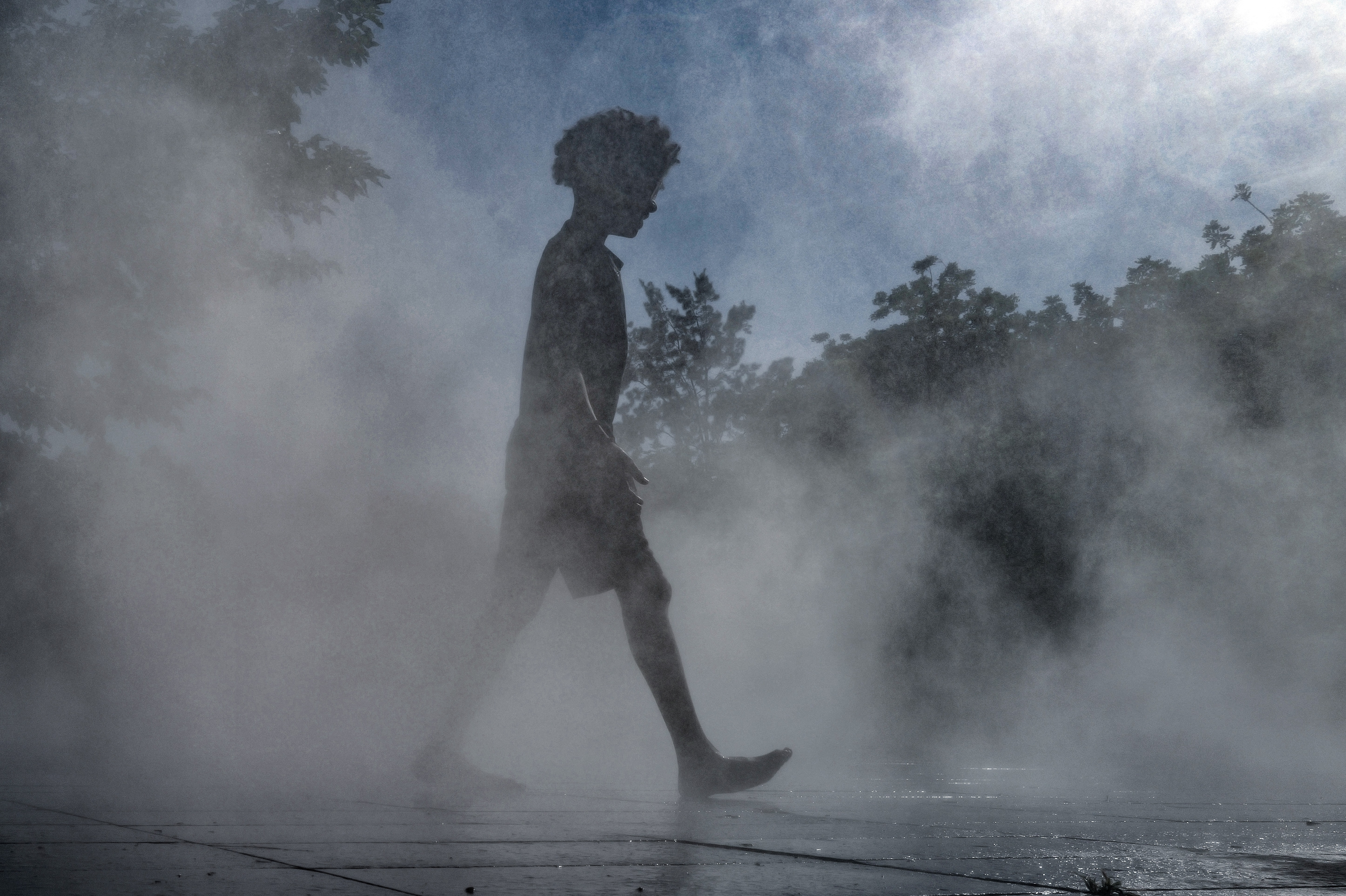 A child walks through a water fountain in Nice. (Photo by Valery HACHE / AFP)