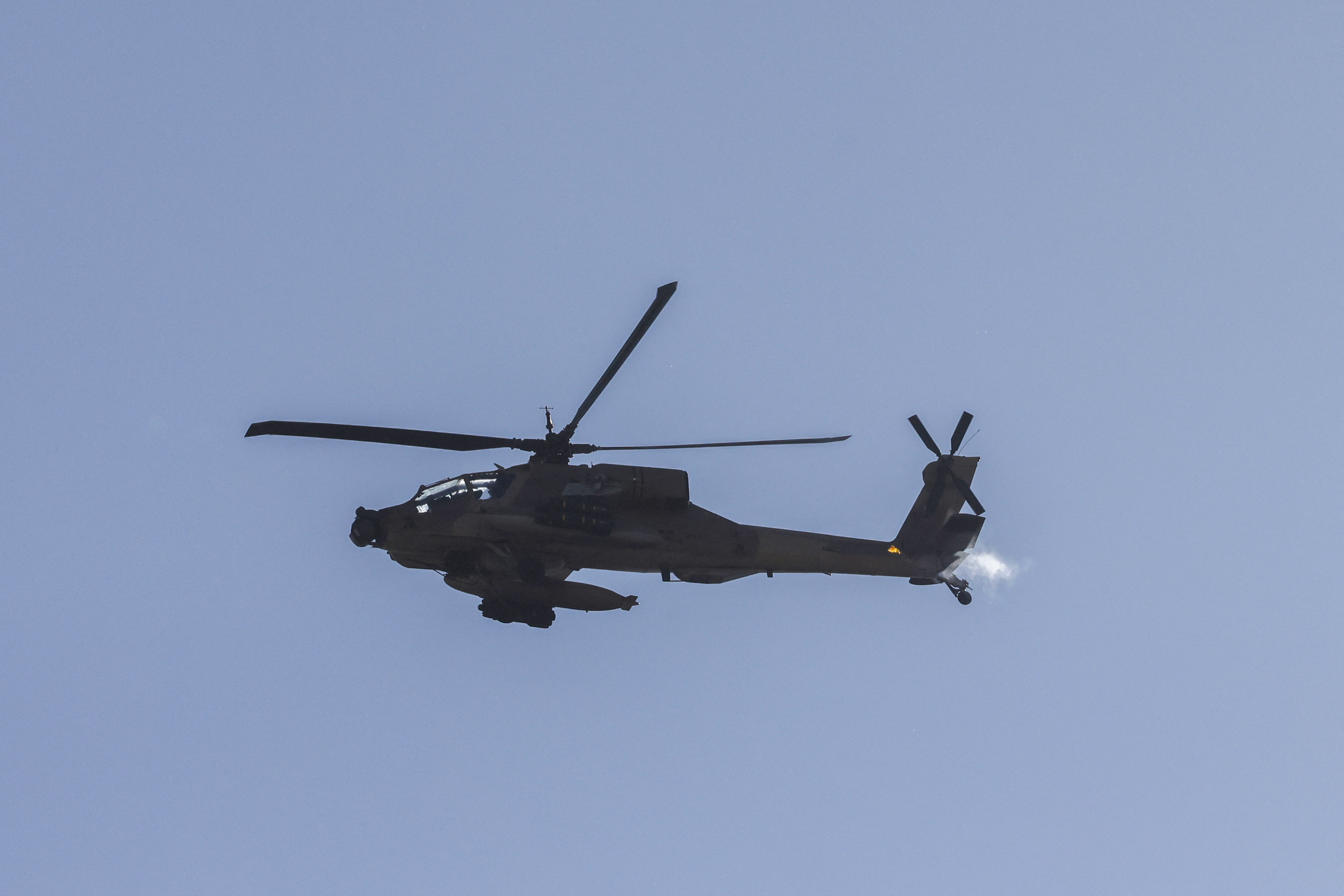 This picture taken from a position in northern Israel, on the border with southern Lebanon, shows an Israeli Air Force AH-64 Apache helicopter flying