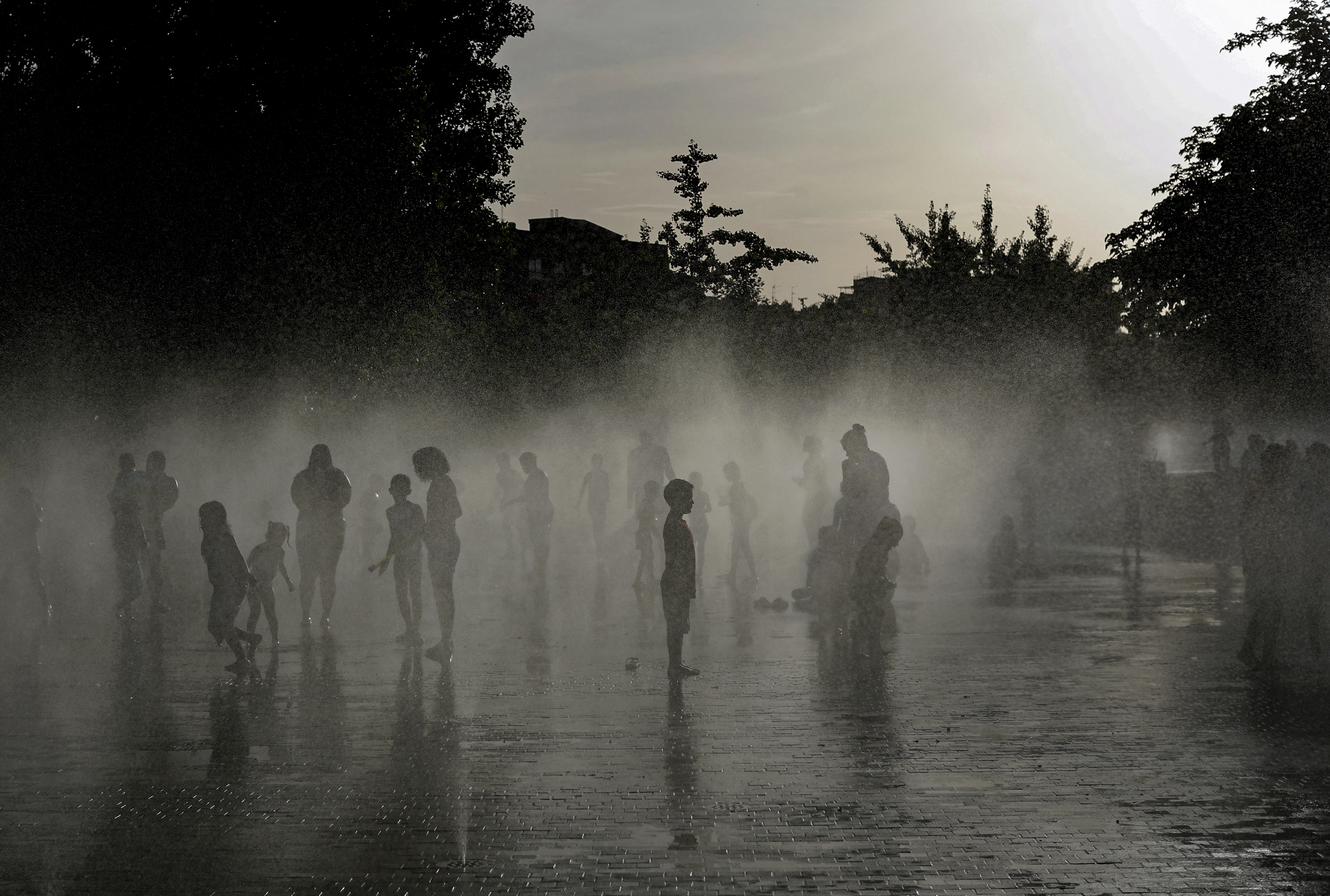 People off in a water fountain as Spain experiences a heatwave, in Madrid on June 23, 2026.