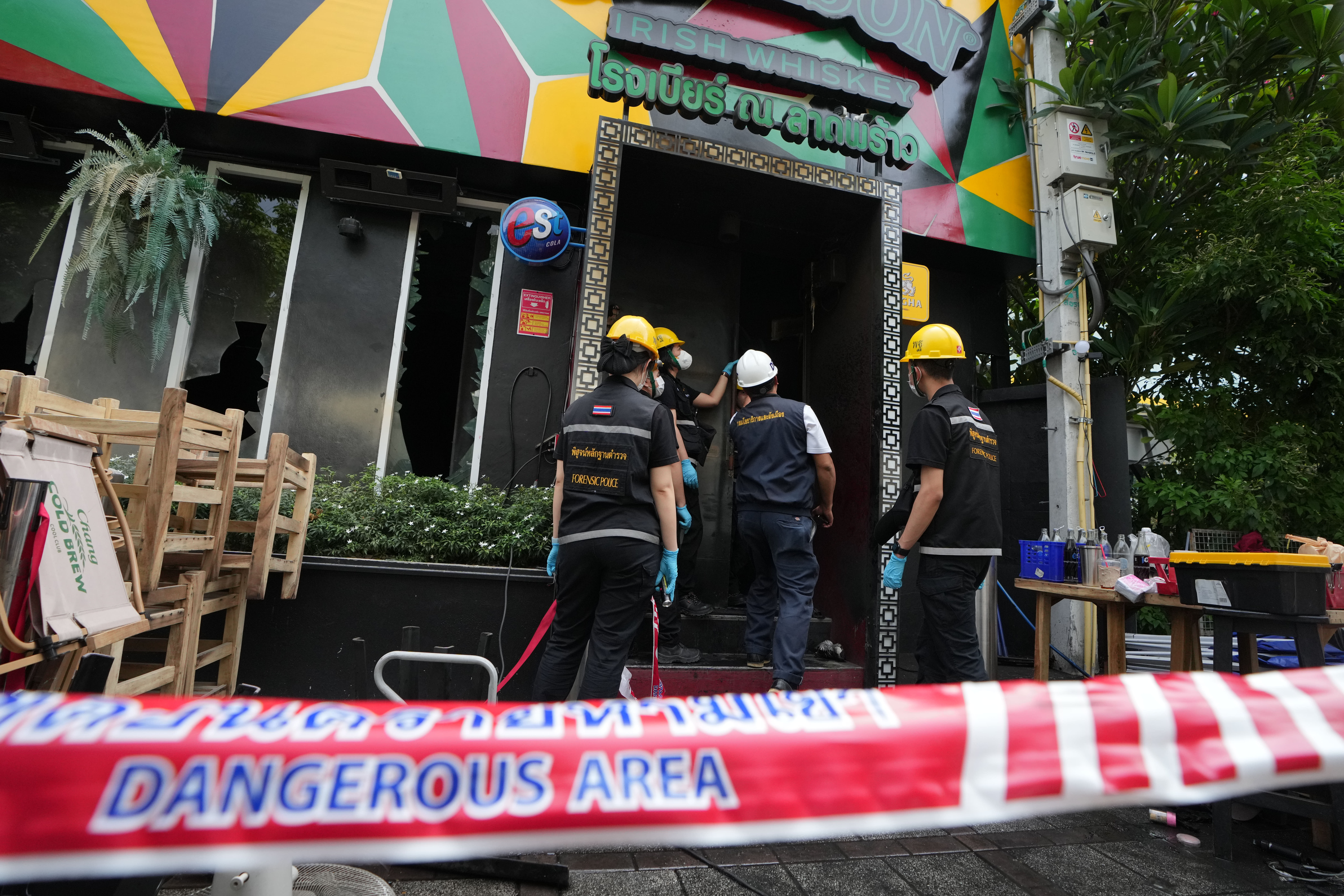 Forensic police officers inspect the site of a fire in Bangkok. (AP Photo/Sakchai Lalit)