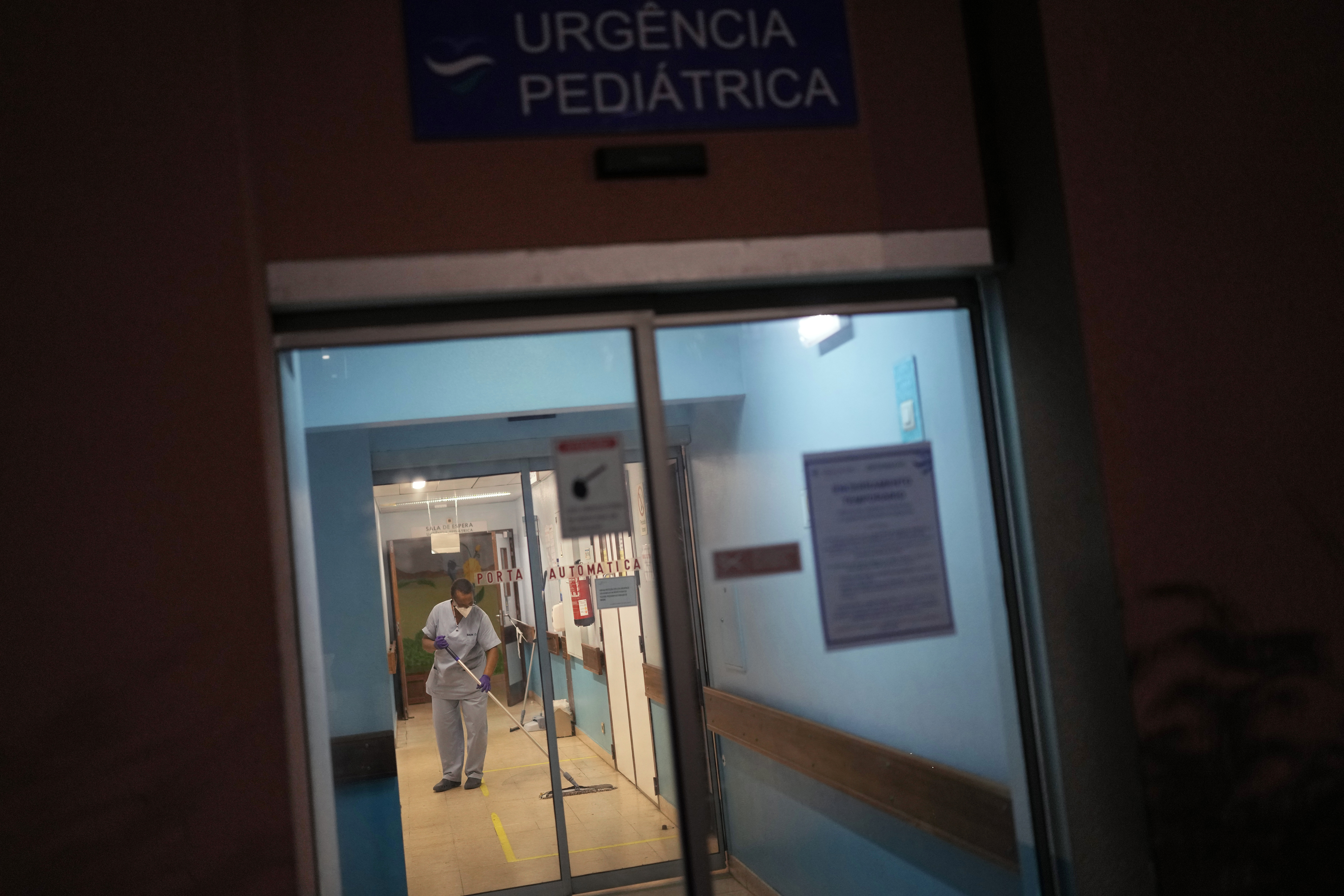 A worker wipes the floor by the pediatric emergency entrance at Almada. (AP Photo/Armando Franca)
