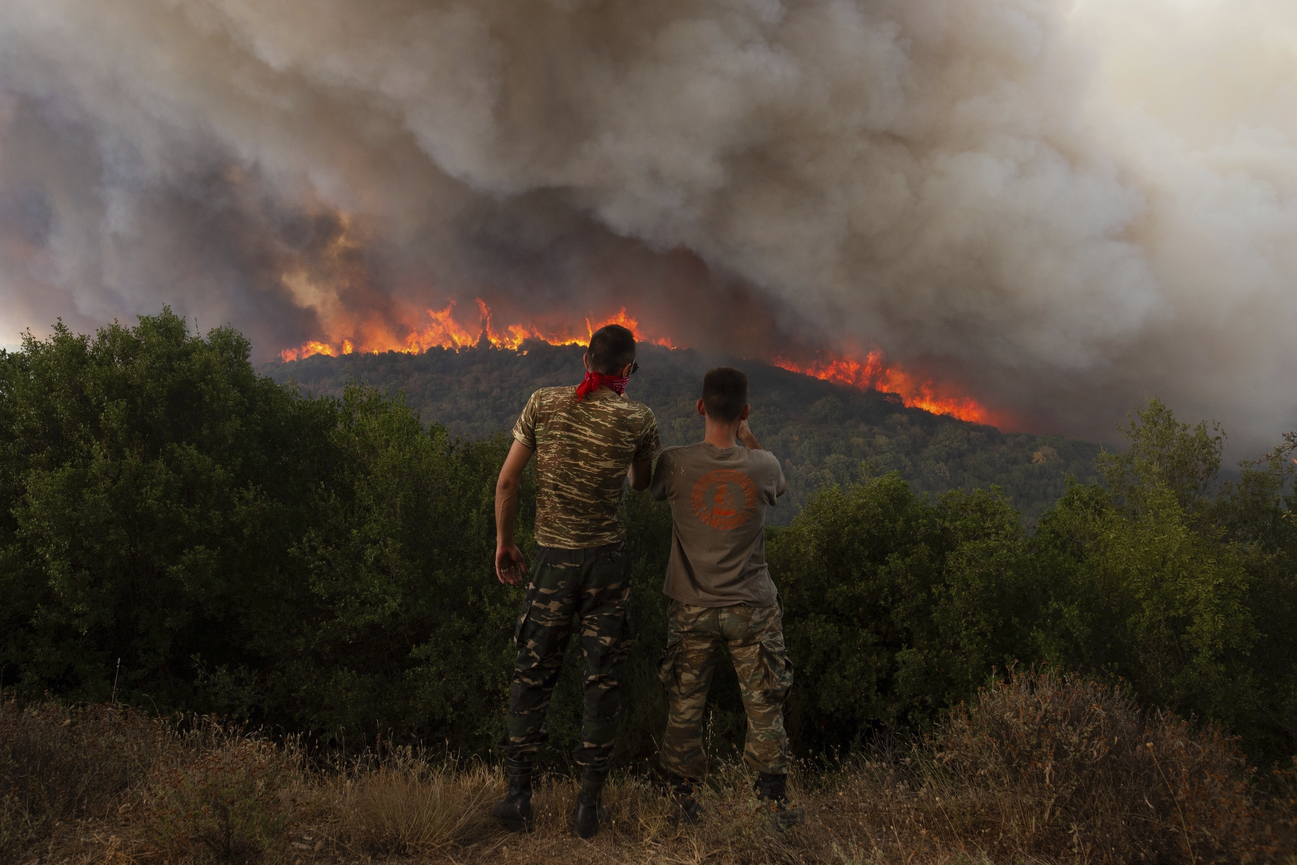 FILE - Flames burn a forest during wildfires near the village of Sykorrahi. (AP Photo/Achilleas Chiras, File)