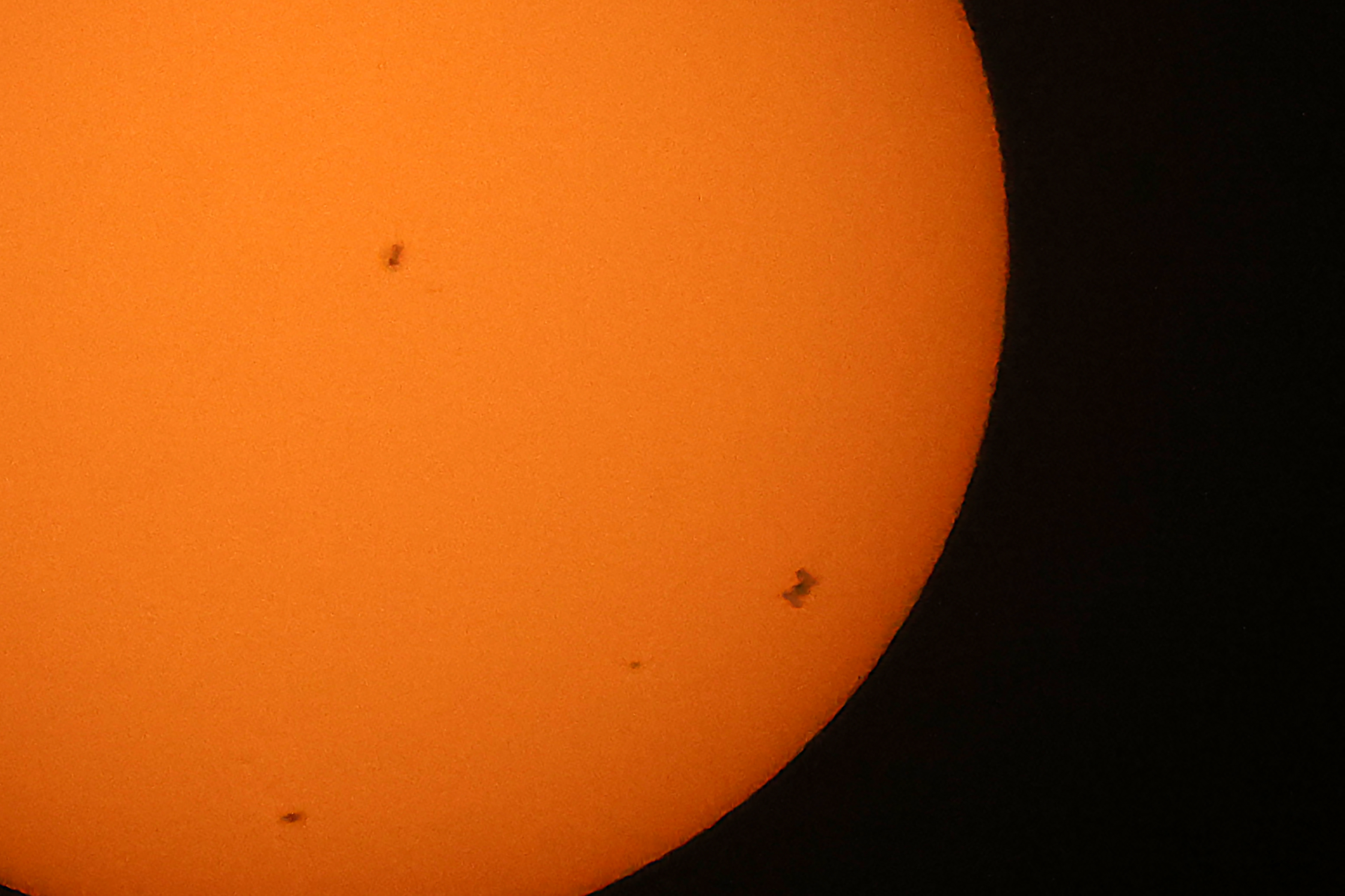 The International Space Station (ISS), (Bottom R) transits the sun as seen from Shuwaikh industrial district in Kuwait City on June 14, 2026.