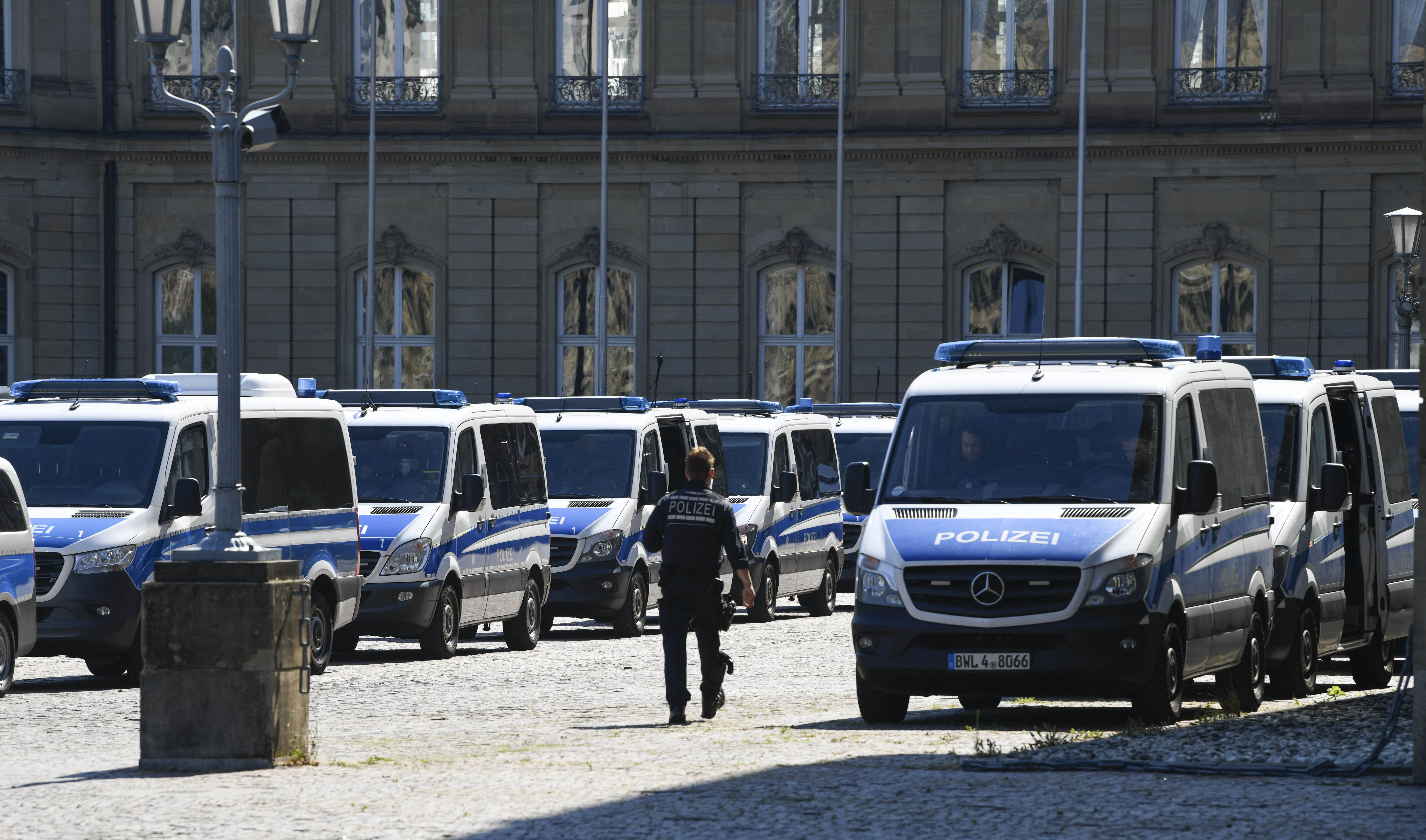Police cars are lined up in front of the New Caste in Stuttgart, southern Germany, on August 8, 2020, prior to a demonstration against the restrictions amid the coronavirus pandemic. (Photo by THOMAS KIENZLE / AFP)