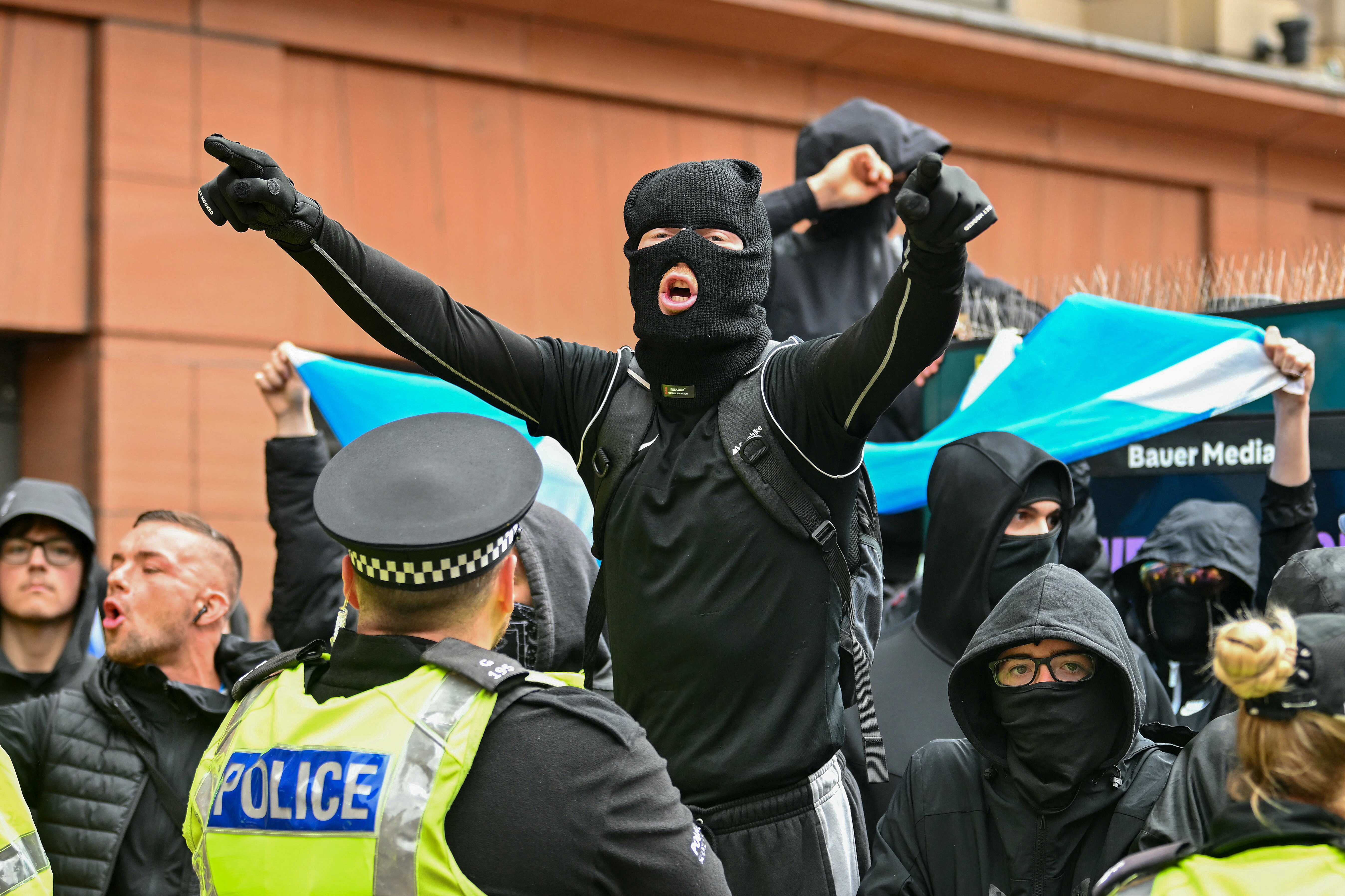 Police hold back protesters who have come out to counter-protest against an anti-racism demonstration in central Glasgow, Scotland