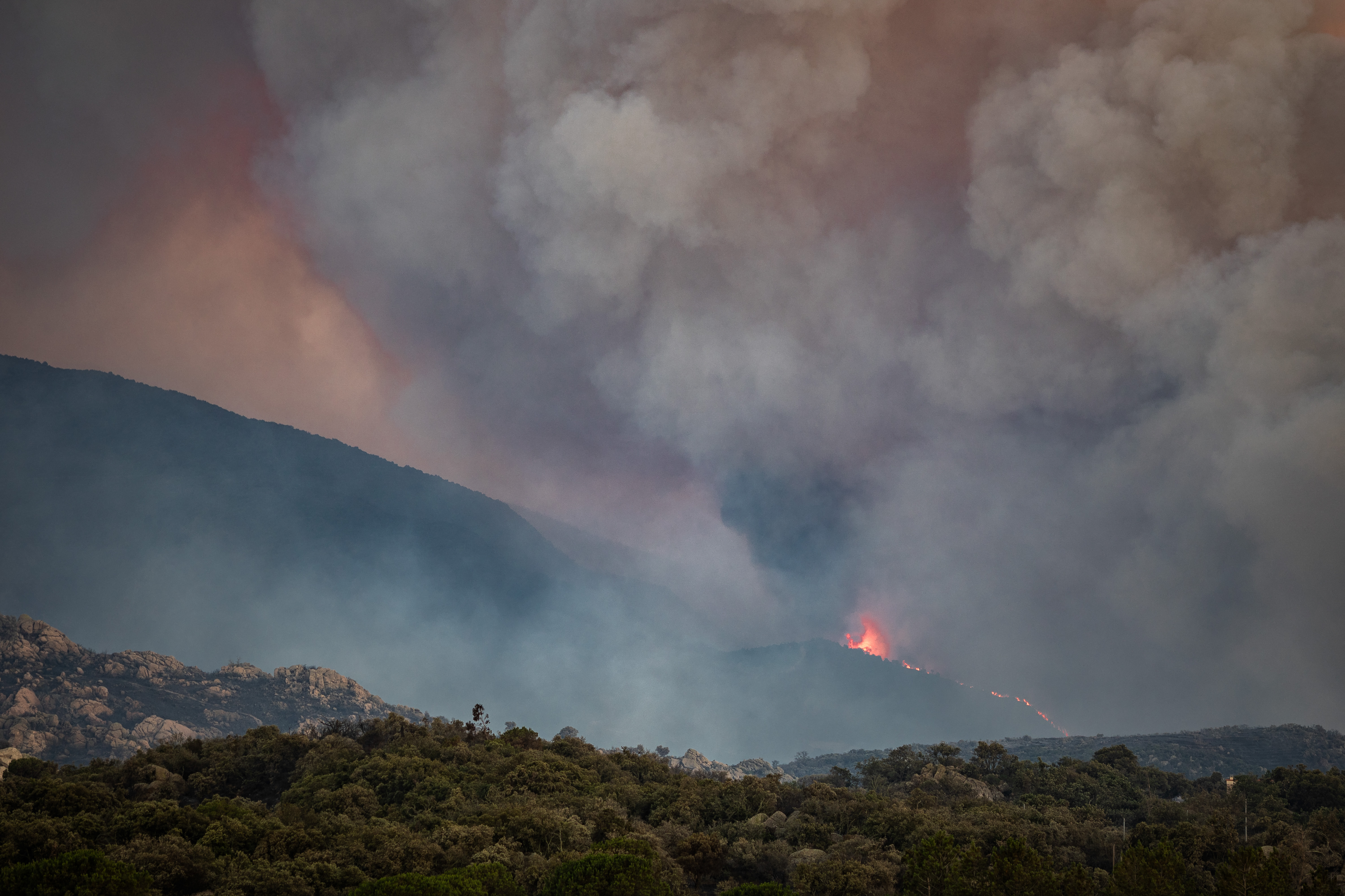 This photograph shows a cloud of smoke from a wildfire burning in the Aspres region seen from Montalba-le-Chateau, in the Pyrenees-Orientales department