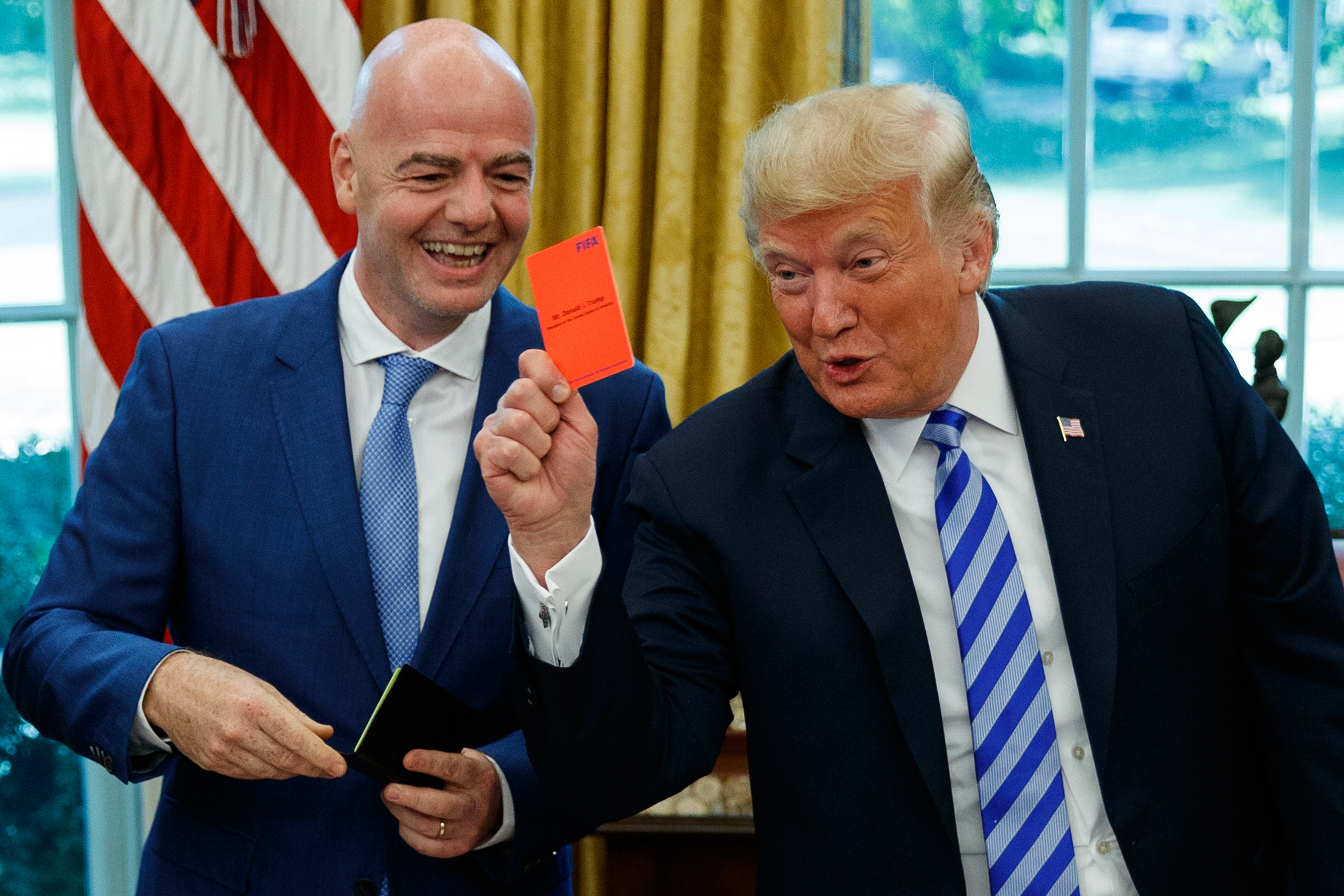 President Donald Trump holds up a red card during a meeting with FIFA president Gianni Infantino. (AP Photo/Evan Vucci, File)