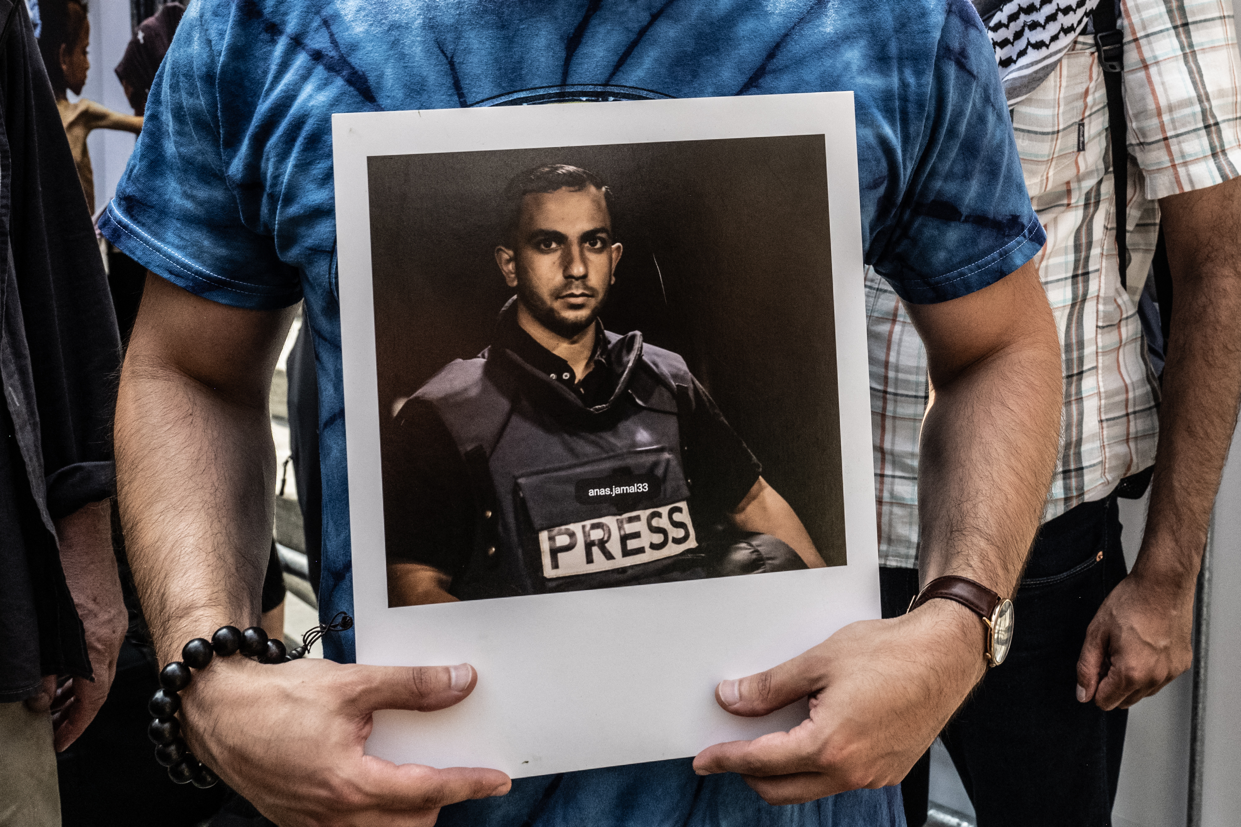 NEW YORK, NEW YORK - AUGUST 16: A person holds a photo of slain Al Jazeera journalist Anas al-Sharif, as Pro-Palestinian protesters participate in a "March for Humanity" against the humanitarian crisis in Gaza