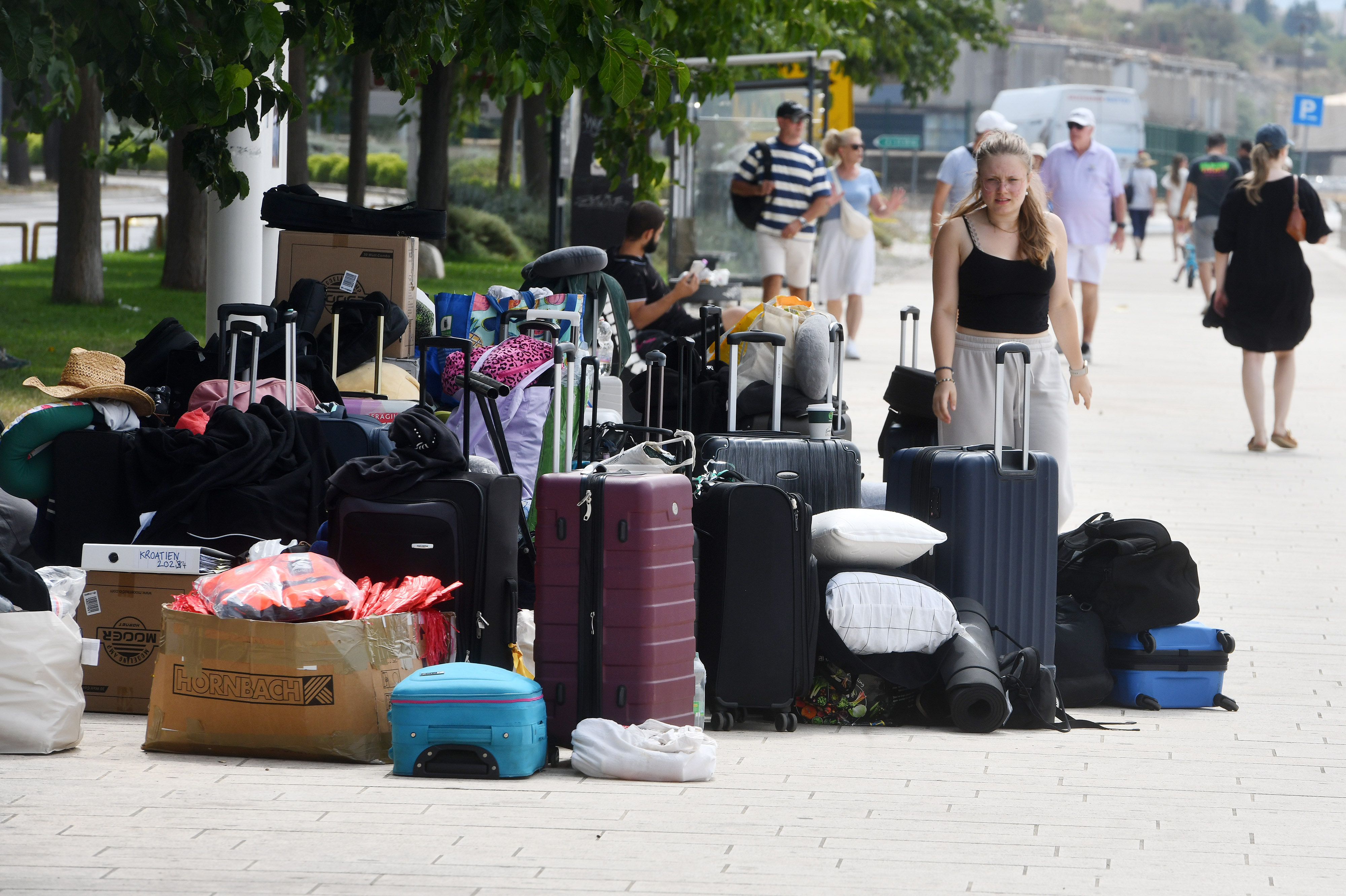 23.07.2024., Sibenik - Turisti u iscekivanju broda za sibenske otoke prtljagu poslozili na rivu. Photo: Hrvoje Jelavic/PIXSELL