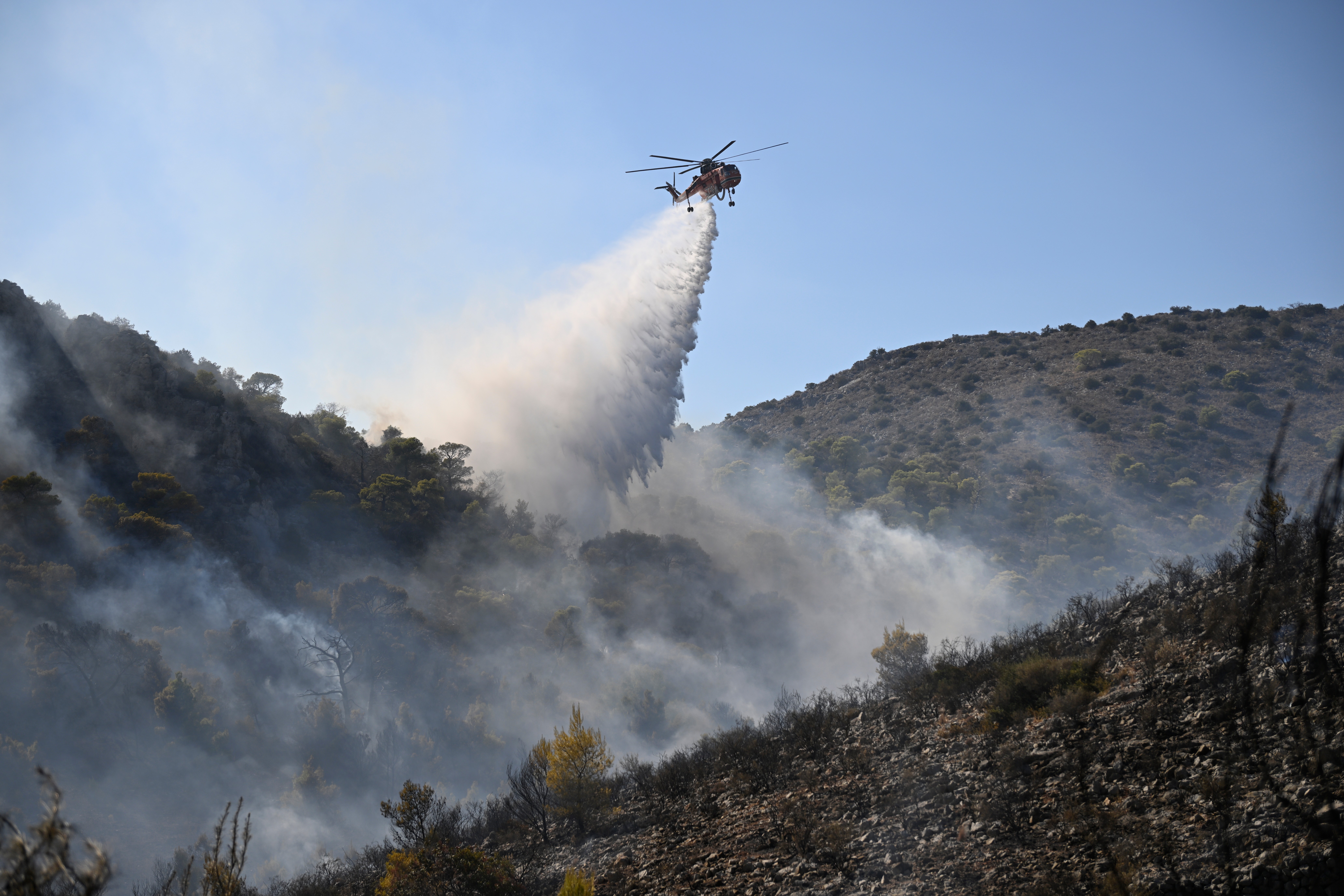 A helicopter drops water on a wildfire on the island of Salamina. (AP Photo/Michael Varaklas)