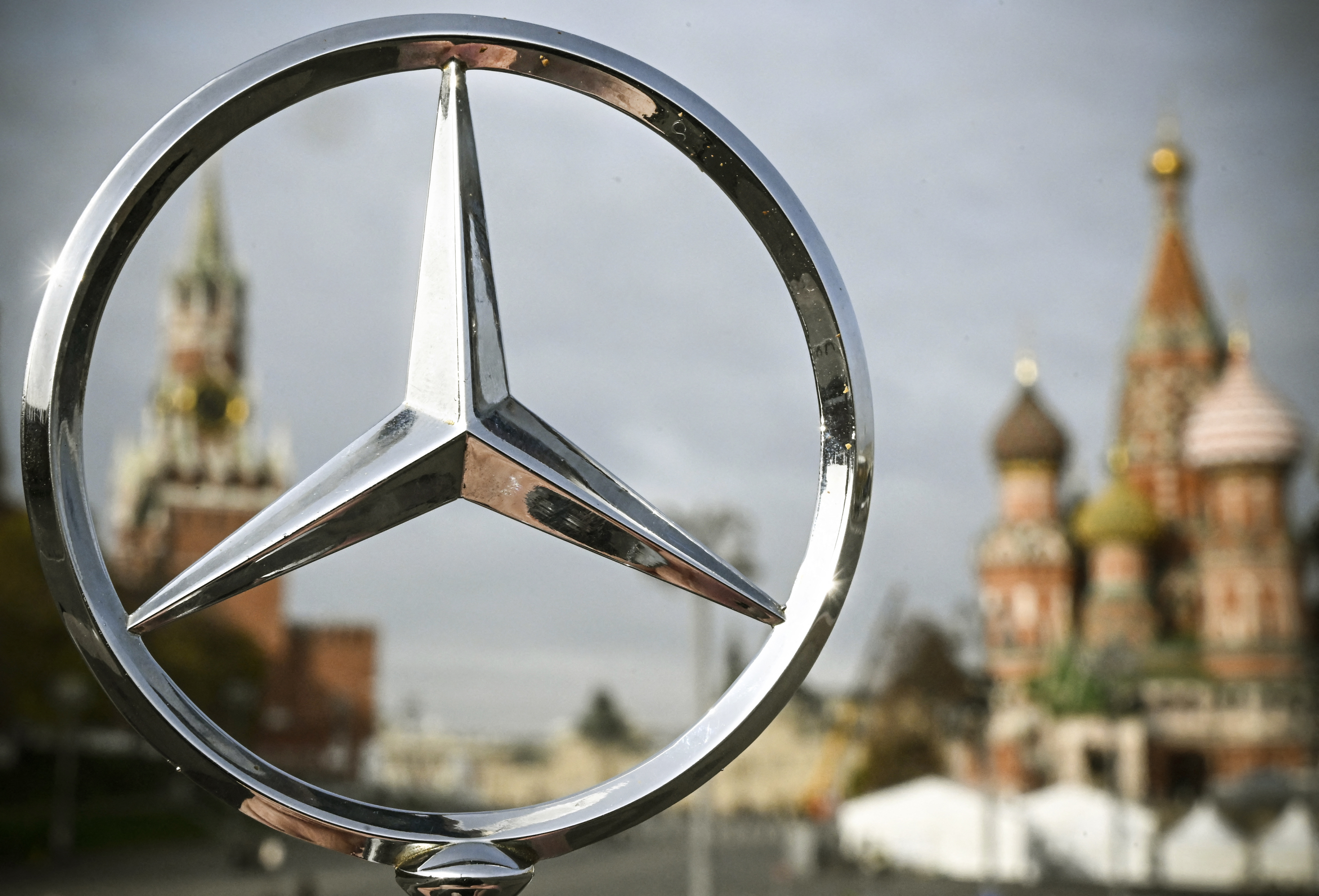 Mercedes Benz logotype in front of the Kremlin and St. Basil's cathedral in central Moscow. (Photo by Alexander NEMENOV / AFP)