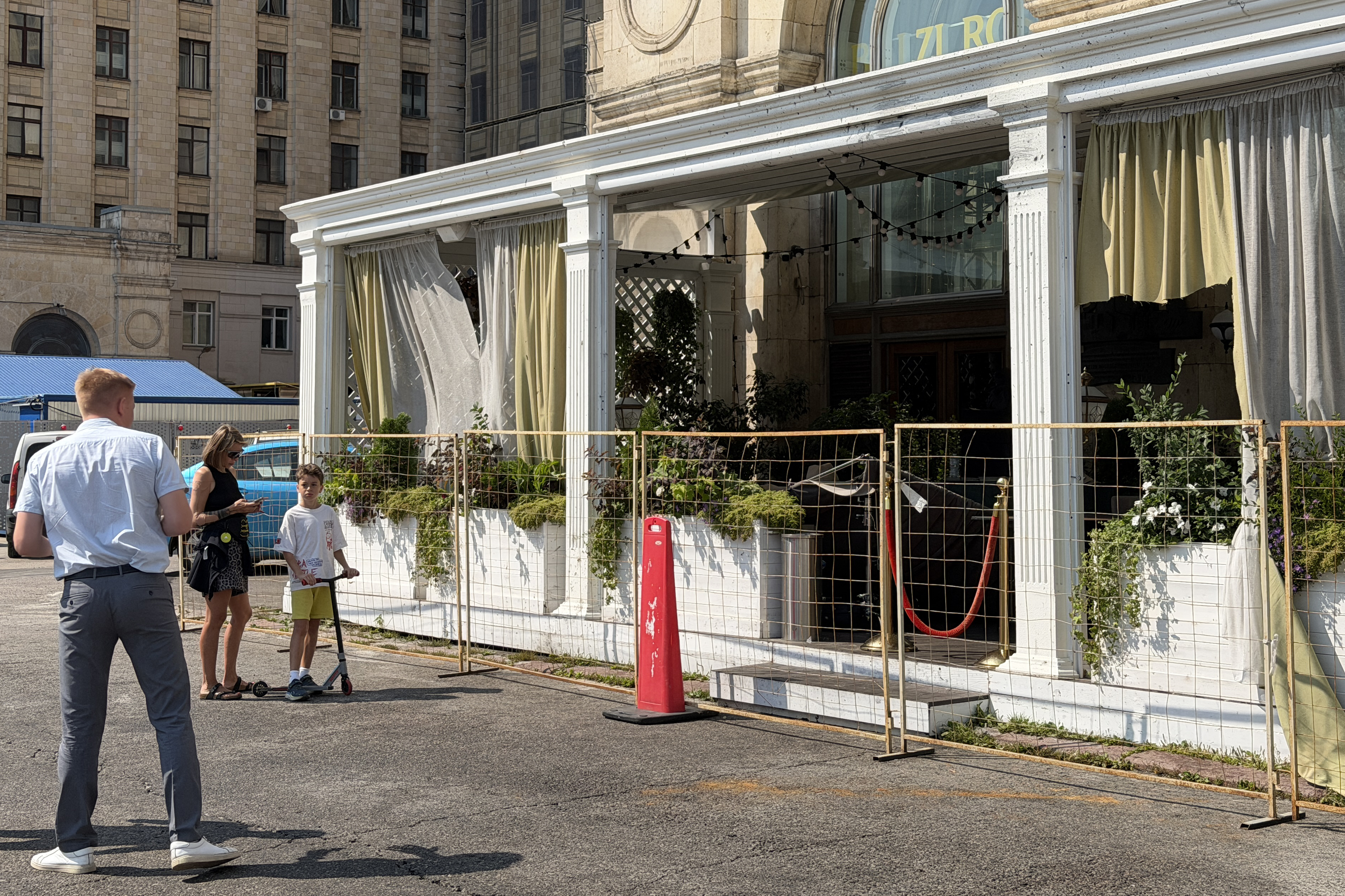 People stand next to the fenced terrace of a restaurant in Moscow on August 2, 2026, the day after a blast. (Photo by Tatyana MAKEYEVA / AFP)