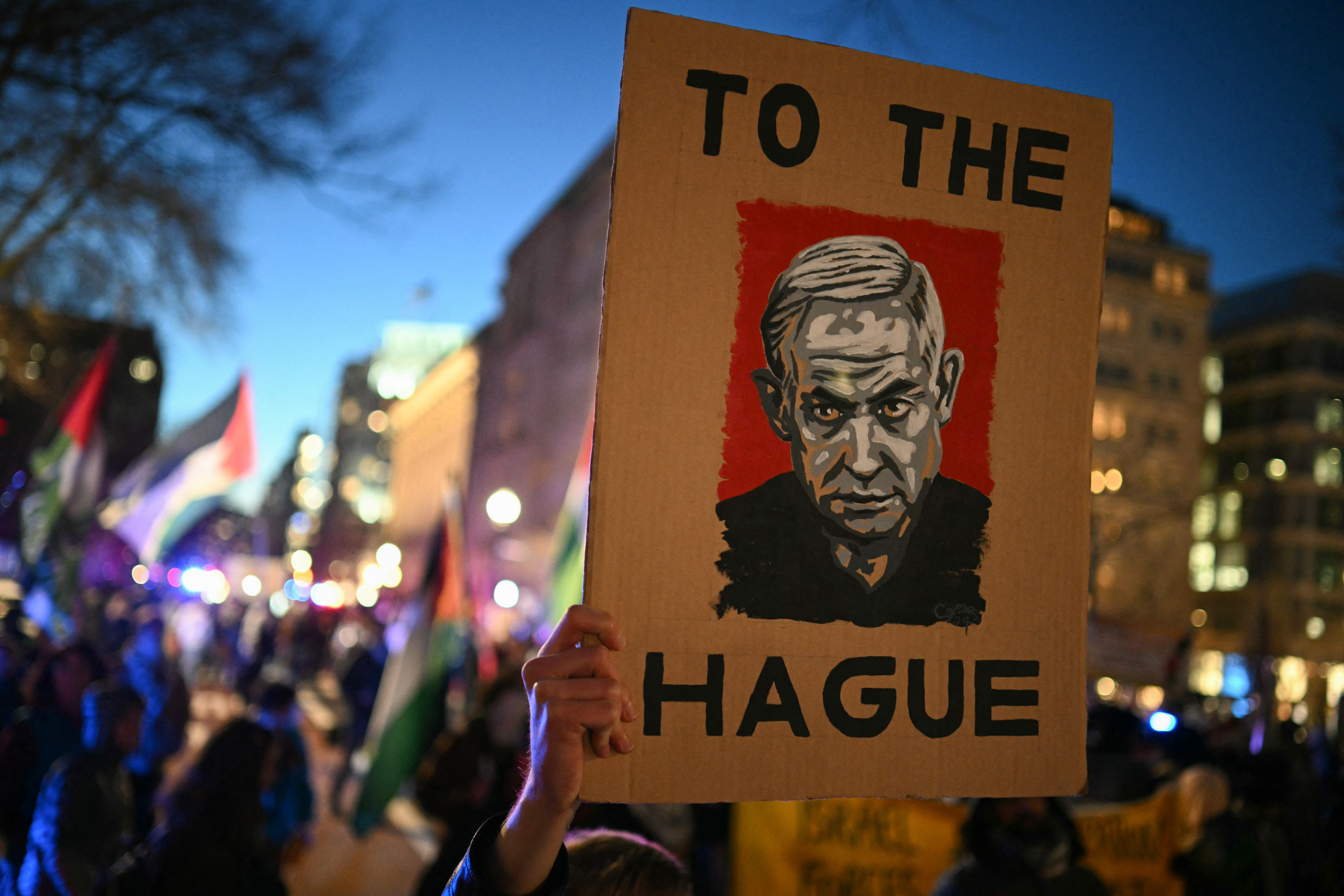 A protester holds up a poster with an image of Israeli Prime Minister Benjamin Netanyahu as they rally in support of Palestinians during the "Arrest Netanyahu at the White House Rally" near the White House in Washington, DC, on February 4, 2025.
