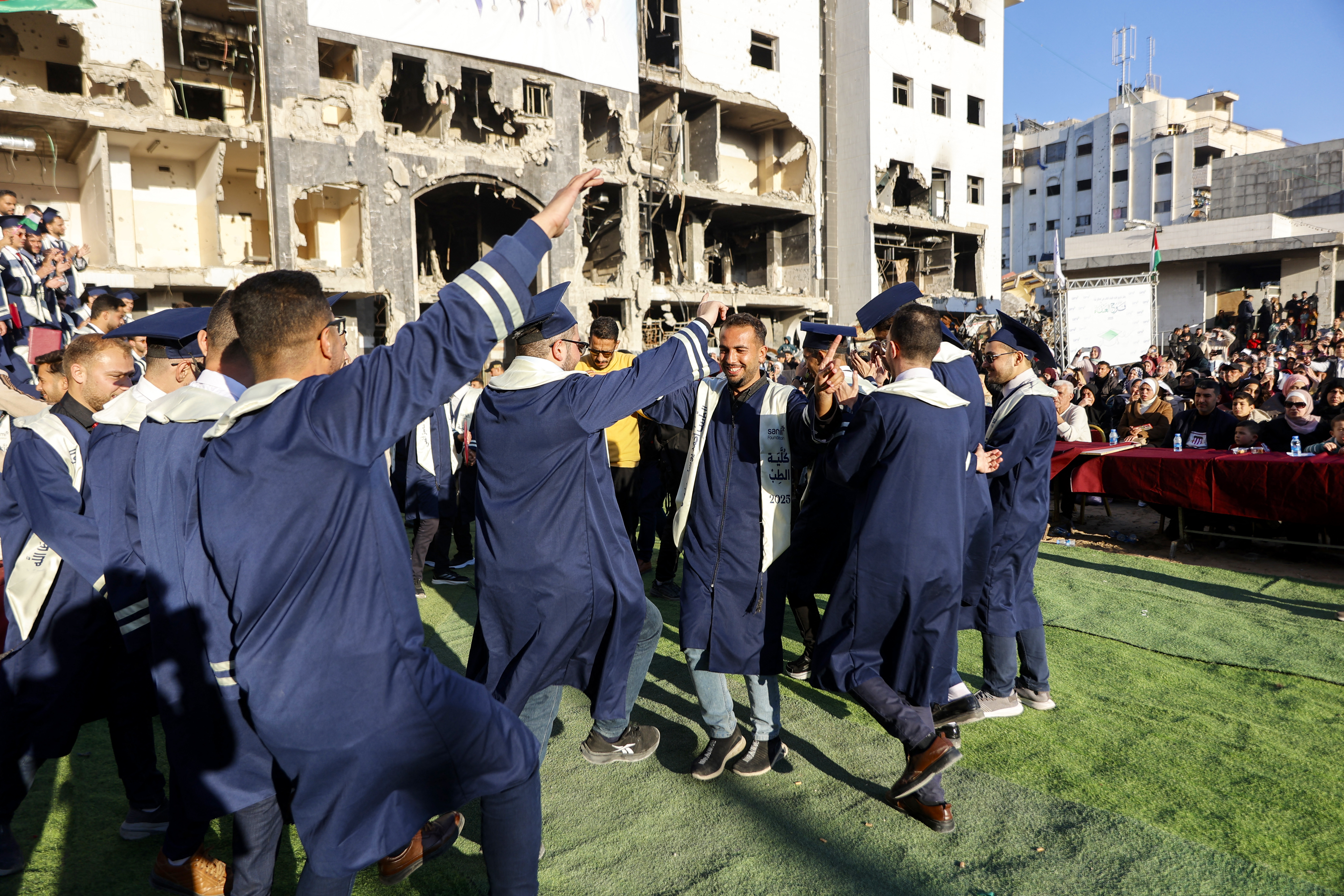 Students from the faculties of medicine at the Islamic and Al-Azhar universities celebrate during the graduation ceremony of 230 doctors in the courtyard of Al-Shifa hospital in Gaza City