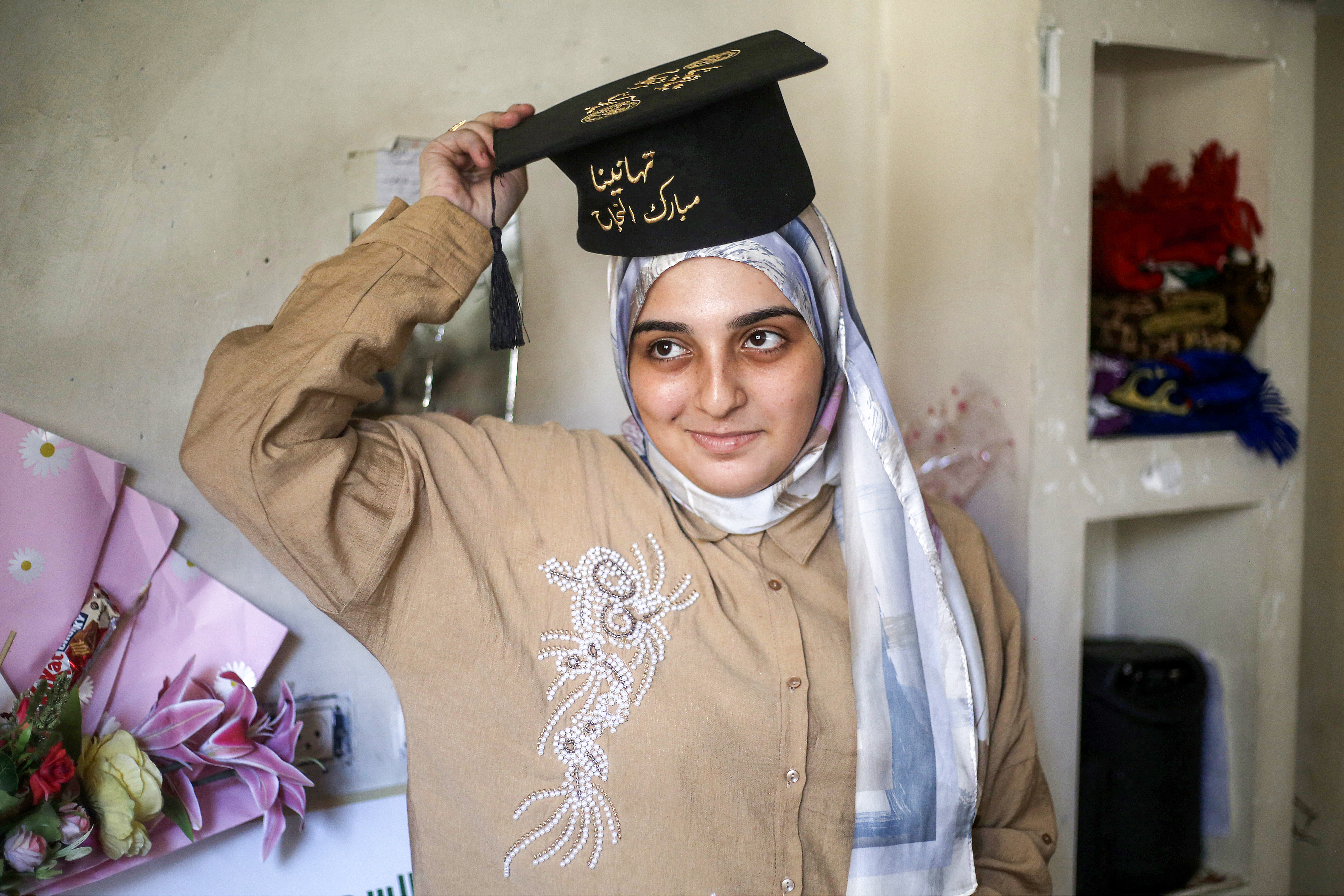Palestinian highschool student Saba Rabah, the top-ranked student in the science stream of the Palestinian national high school exams, celebrates with family at the Maghazi camp for Palestinian refugees in the central Gaza Strip on July 26, 2026.