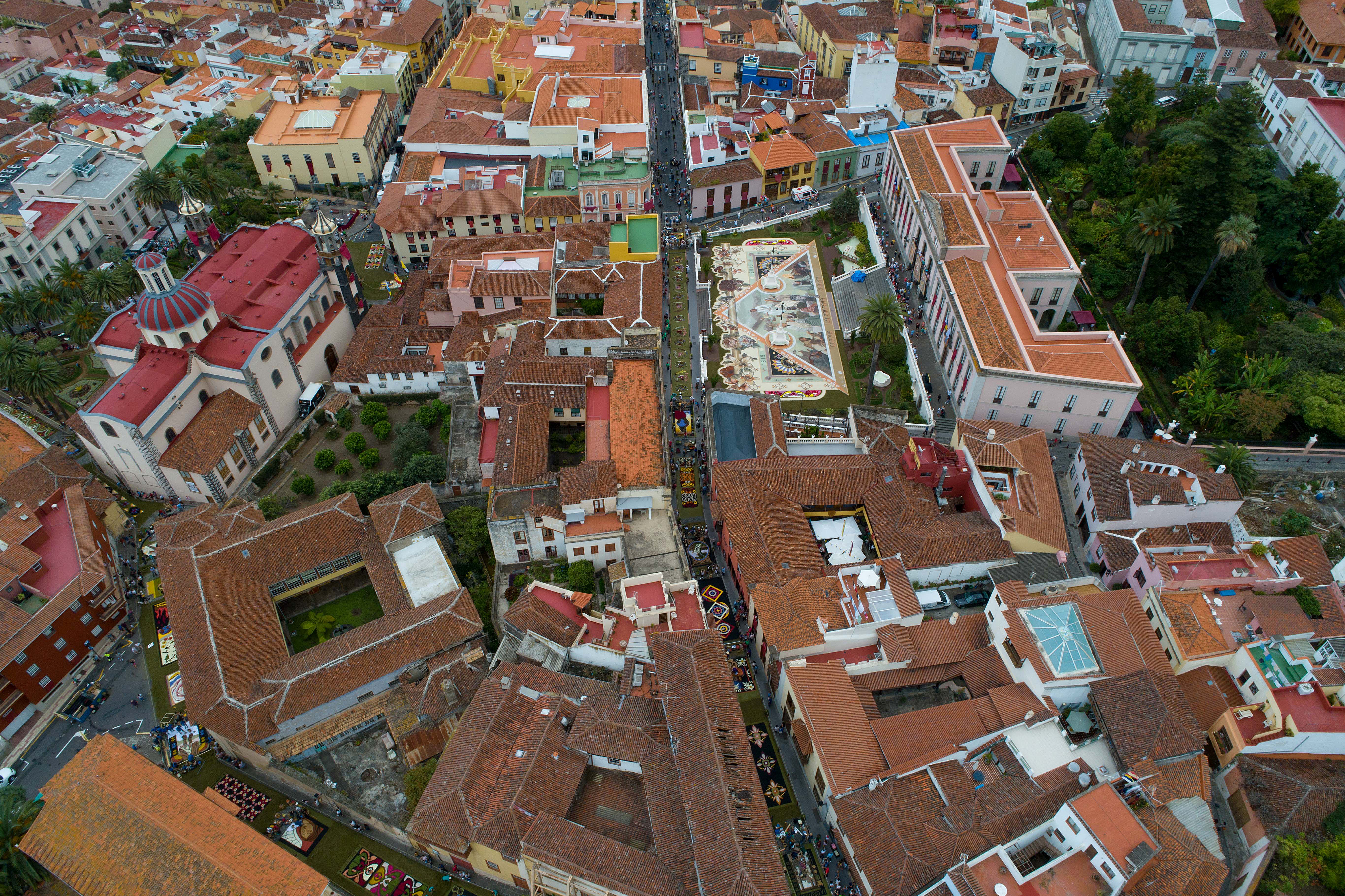 An aerial view shows people making carpets out of sand and flowers during the Corpus Christi Feast in the town of La Orotava on the Spanish Canary Island of Tenerife on June 27, 2019.