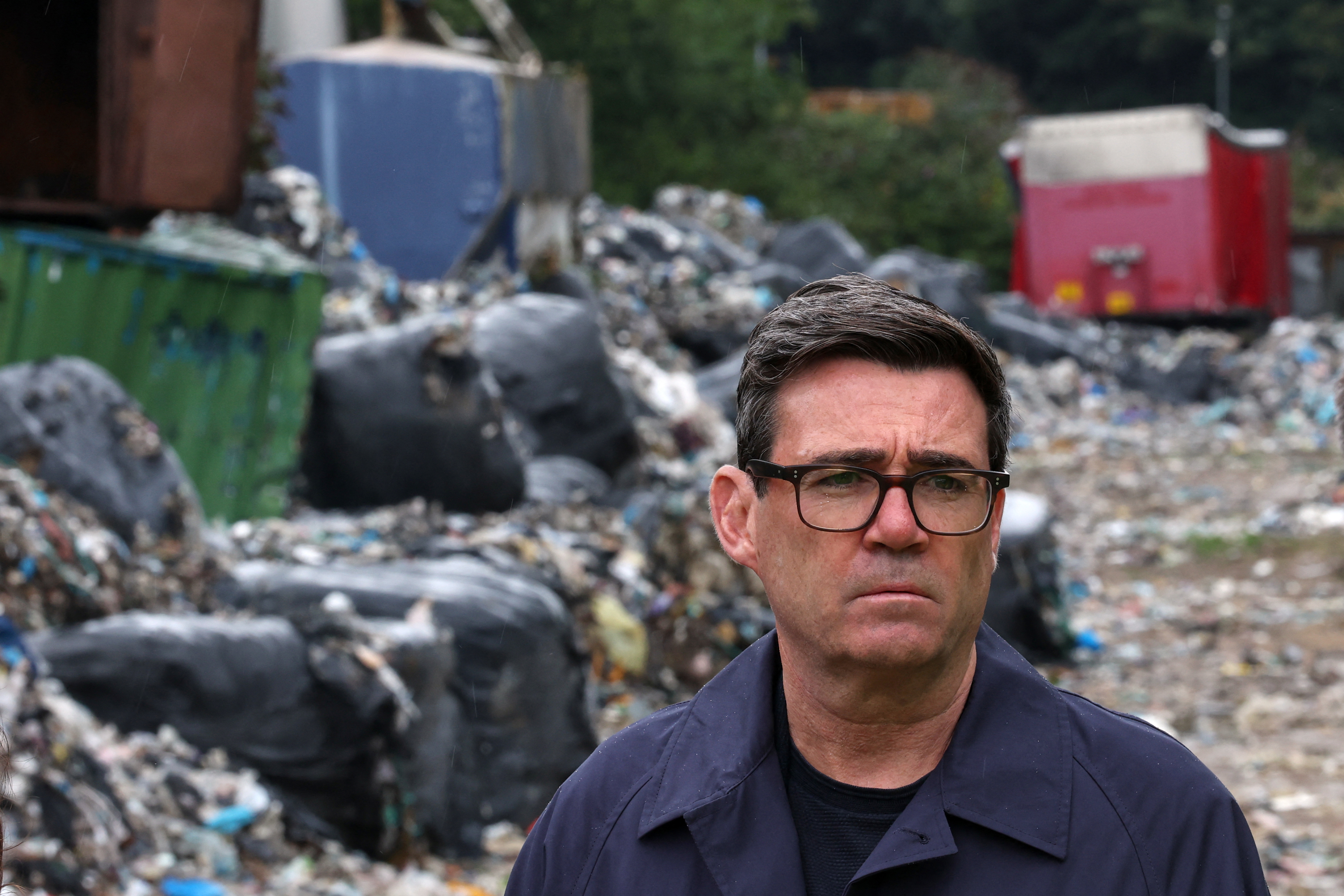 Britain's Prime Minister Andy Burnham is shown an illegal rubbish dump near the Bradford City football ground in Bradford, northern England