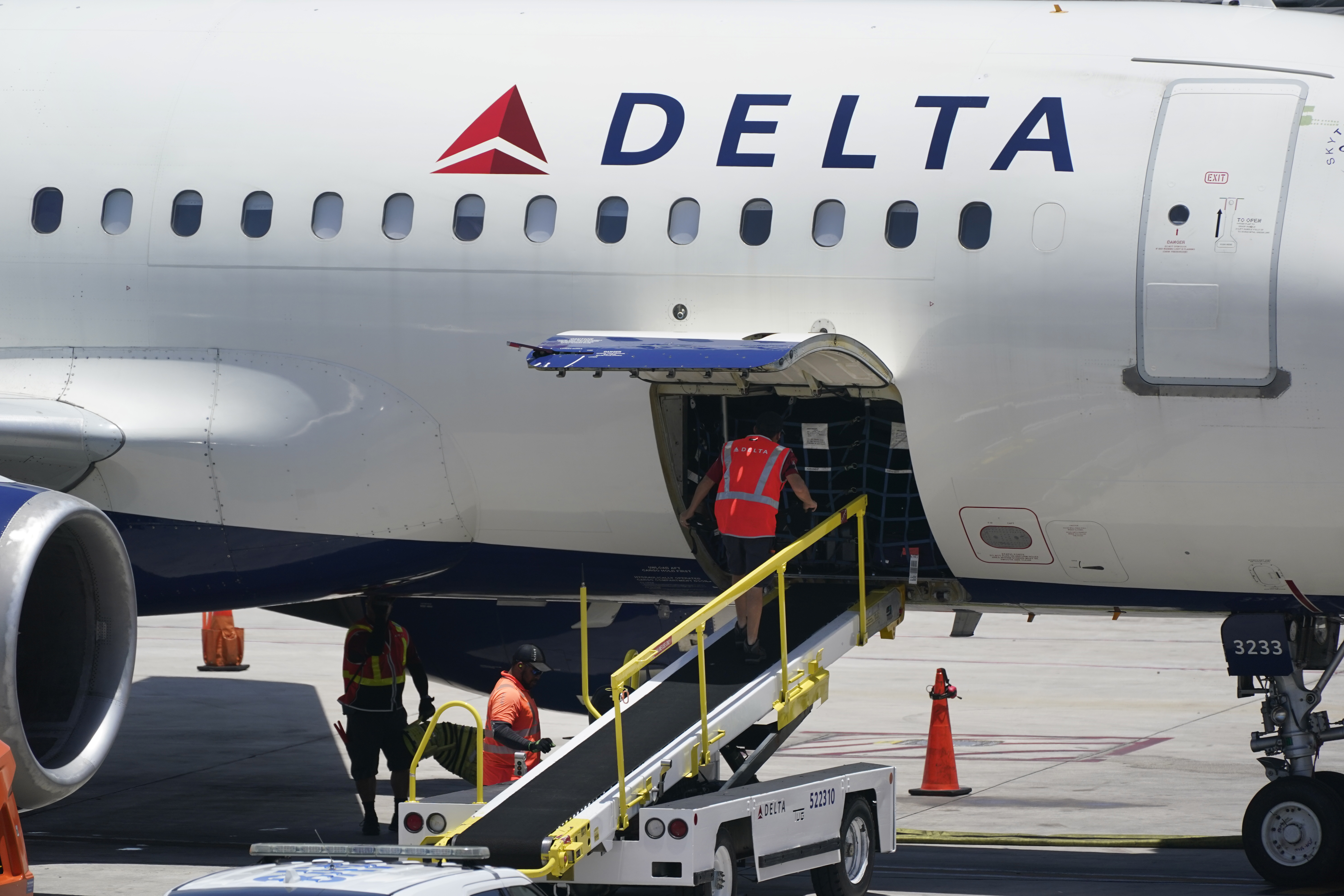 FILE - Workers unload a Delta Air Lines Airbus A320 at the Fort Lauderdale-Hollywood International Airport in Fort Lauderdale, Fla