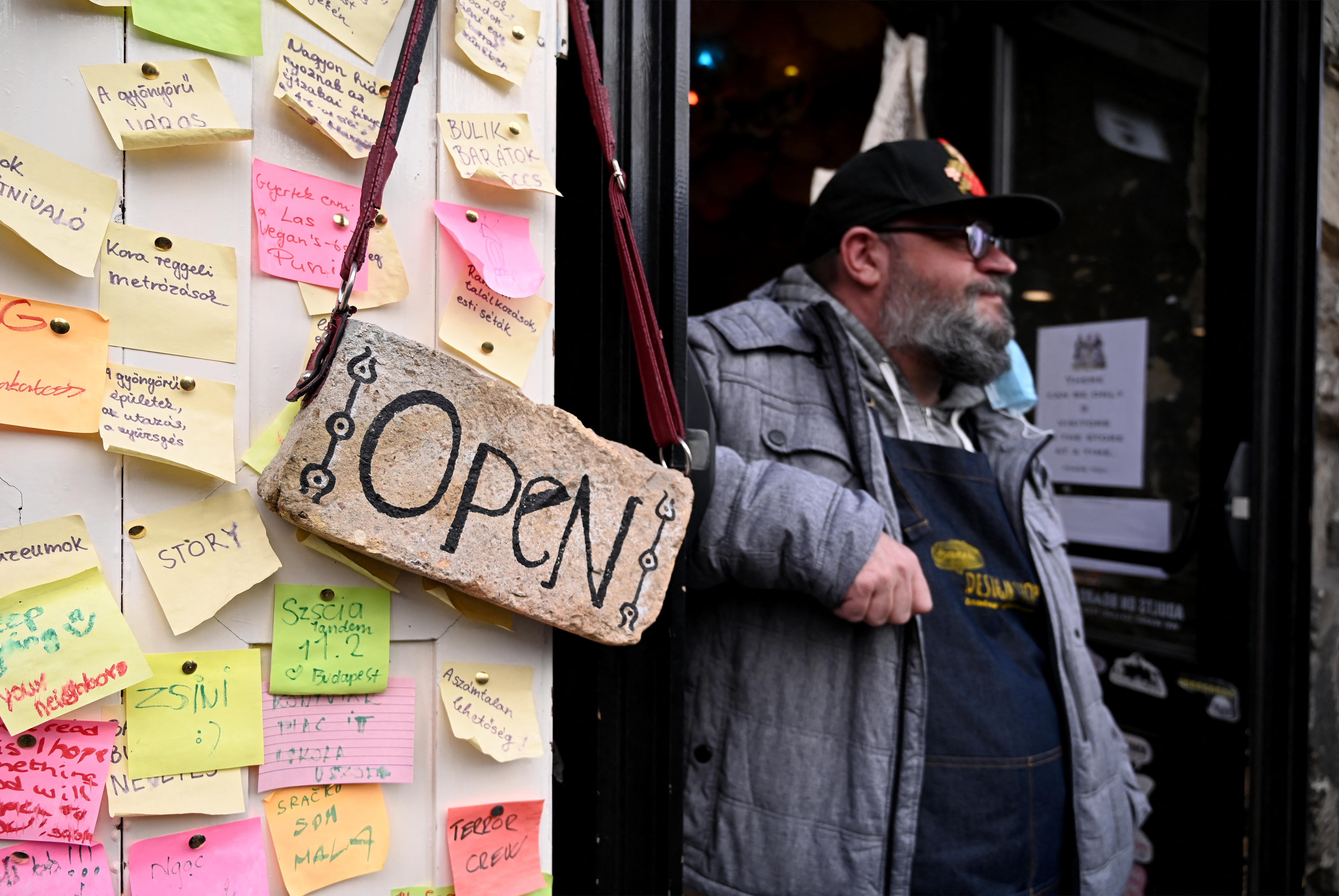 An employee stands next to an "open" sign at the famous ruin pub 'Szimpla Kert' (Simple Garden) in Budapest, Hungary on April 23, 2021