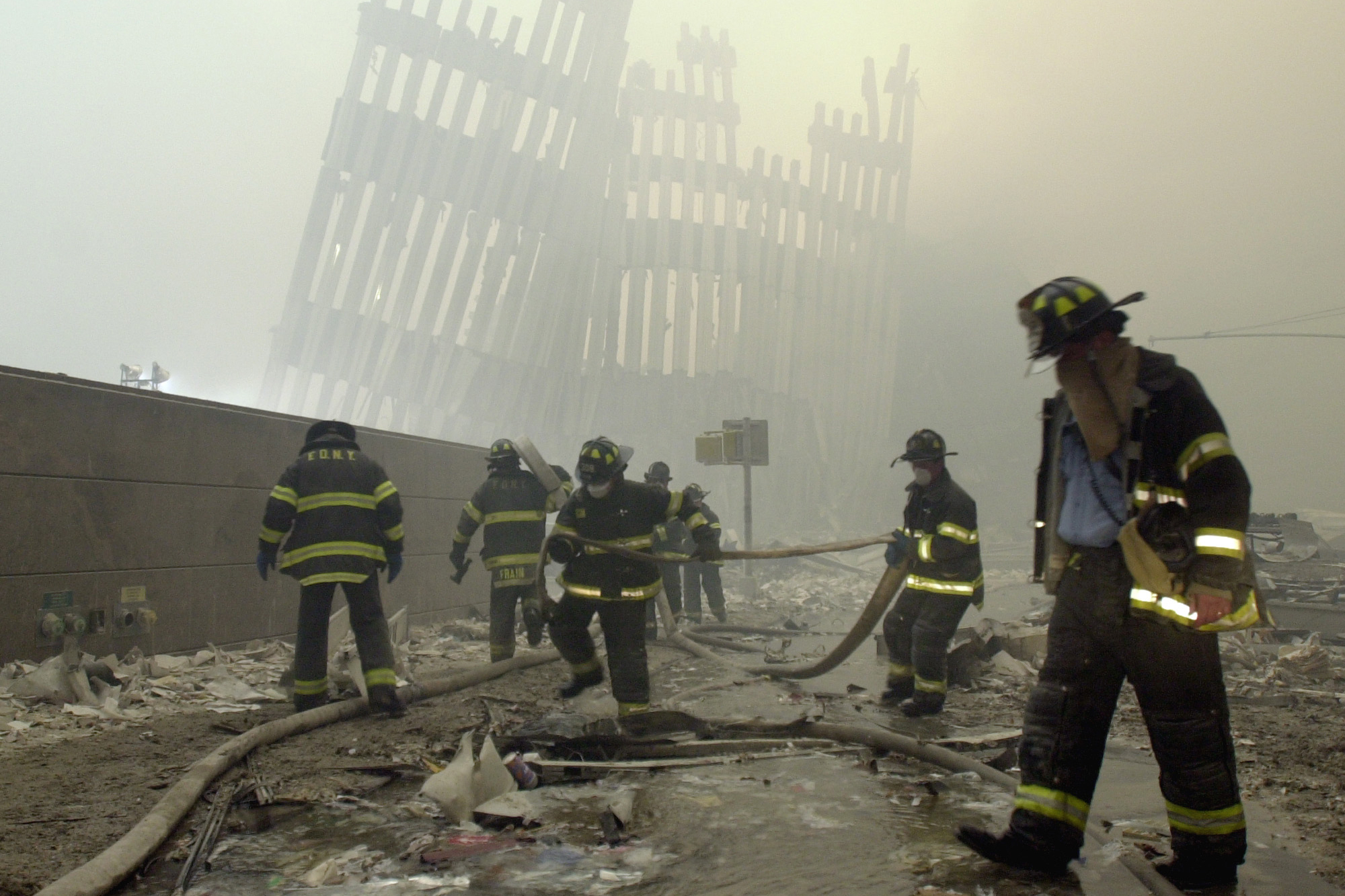 Sept. 11, 2001 photo, firefighters work beneath destroyed mullions. (AP Photo/Mark Lennihan, File)