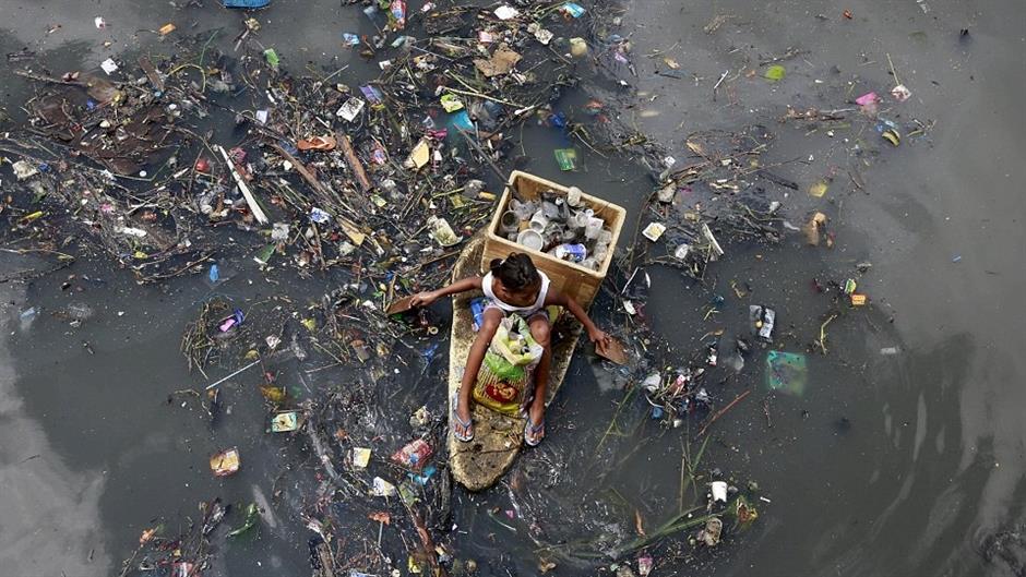 2A29C62700000578-3148193-Unsafe_Children_use_makeshift_boats_to_trawl_the_litter_strewn_r-a-10_1435912665014