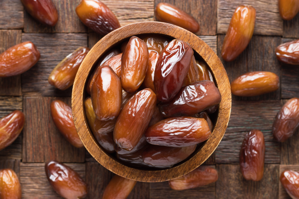Dried,Date,Fruit,In,Bowl,On,Wooden,Table,Background.