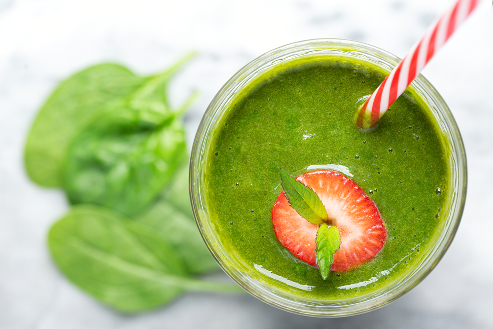 Overhead,View,Of,A,Green,Spinach,Smoothie,With,Strawberry,Garnish