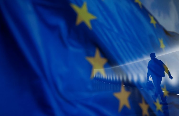 REUTERS/Michele Tantussi/Ilustracija Zastava Europske unije u krupnom planu kroz koju se prozire čovjek