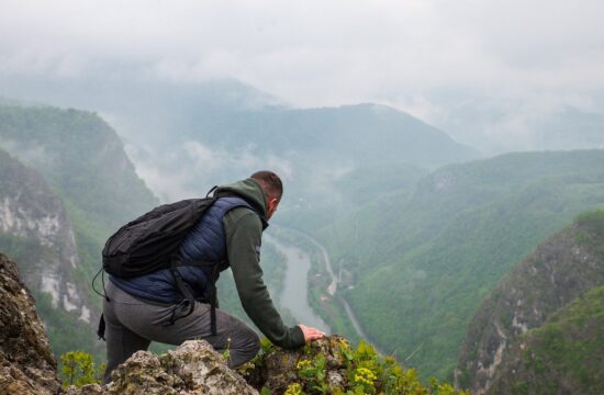 Planinar u prvom planu s pozadinom planinskog lanca u središtu Bosne i Hercegovine u magli