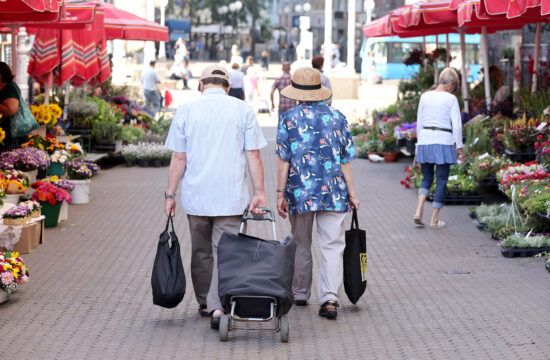 Stariji gospodin i gopođa u šetnji tržnicom