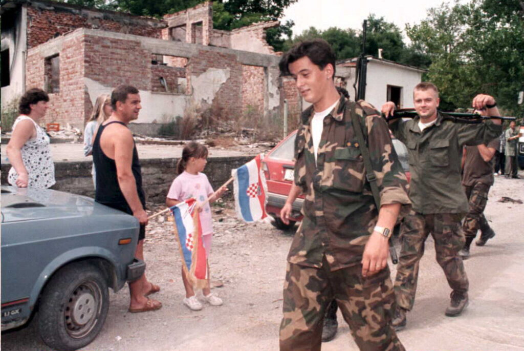 Obitelj povratnika pozdravlja hrvatske vojnike u selu Hrastnica u okolici Petrinje u kolovozu 1995.