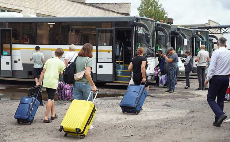 ljudi idu prema autobusima s prtljagom