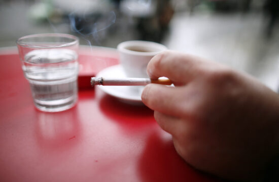 cigareta, pepeljara i šalica kave na stolu u kafiću