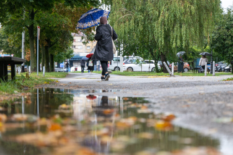 Žena na kiši drži kišobran