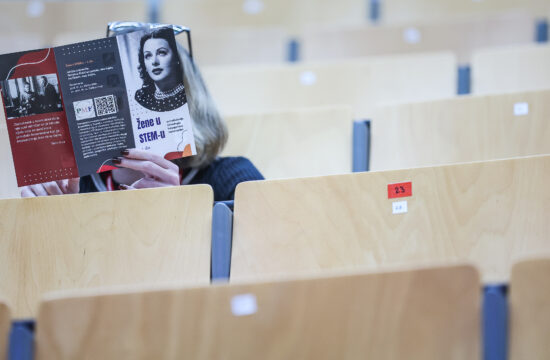 žena drži knjigu "Žene u STEM-u" na konferenciji o ženama u znanosti