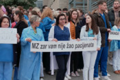 Liječnice i medicinske sestre obučene u liječničke kute drže transparent i štrajkaju